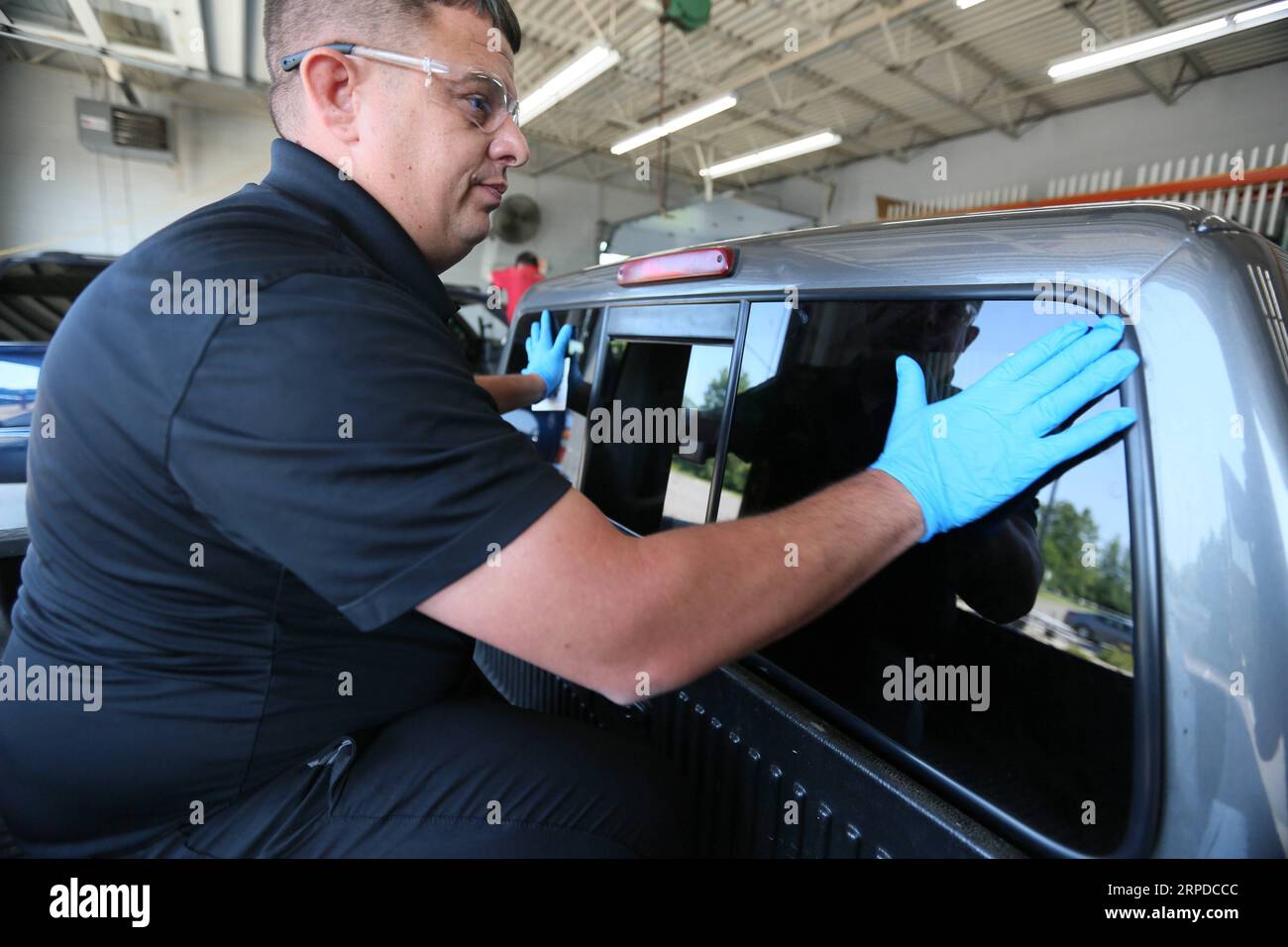 (190731) -- DAYTON, 31. Juli 2019 -- Ein Arbeiter installiert das von Fuyao hergestellte Glas an einem Auto in einer Autowerkstatt in Dayton, Ohio, USA, 26. Juli 2019. Als der chinesische führende Automobilglashersteller Fuyao vor fünf Jahren den Standort des ehemaligen General Motors-Werks in Dayton, Ohio, übernahm, jubelte die lokale Gemeinde dem möglichen Aufschwung zu, der die Revitalisierungsbemühungen der Rostgürtelstadt noch verstärken könnte. Im Jahr 2014 erwarb Fuyao ein ehemaliges Werk von General Motors in Moraine, einer Stadt im Bundesstaat Ohio, und verwandelte den Veranstaltungsort, der während der Finanzkrise von 2008 geschlossen wurde, in eine 2 Millionen Quadratmeter große gla Stockfoto