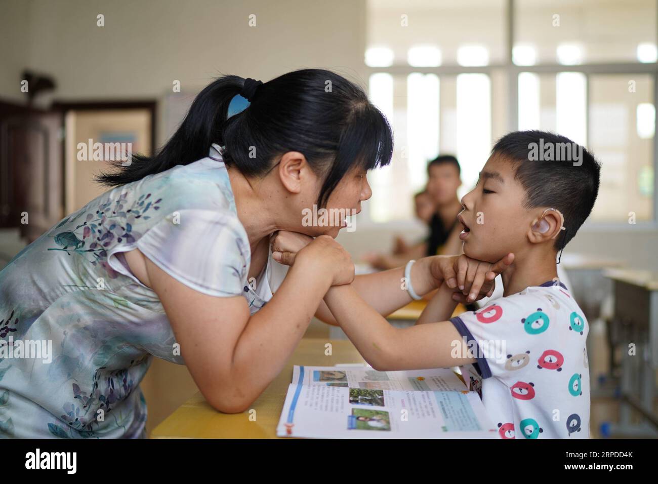 (190731) -- NANCHANG, 31. Juli 2019 -- Liu Xiaoqing (L) legt einer Schülerin während eines Sprach- und Sprachtrainings an der Luxi County Special Education School im Luxi County von Pingxiang in der ostchinesischen Provinz Jiangxi am 3. Juli 2019 die Hand auf ihre Kehle. Als die Luxi County Special Education School 1997 gegründet wurde, bewarb sich Liu Xiaoqing, damals ein normaler Universitätsabsolvent, ohne zu zögern um einen Posten dort. Die Arbeit als Sonderpädagoge war eine Herausforderung, da Lius Schüler viel mehr Aufmerksamkeit benötigen als ihre Kollegen ohne körperliche oder geistige Behinderung. Aber Liu blieb auf ihrem Posten Stockfoto