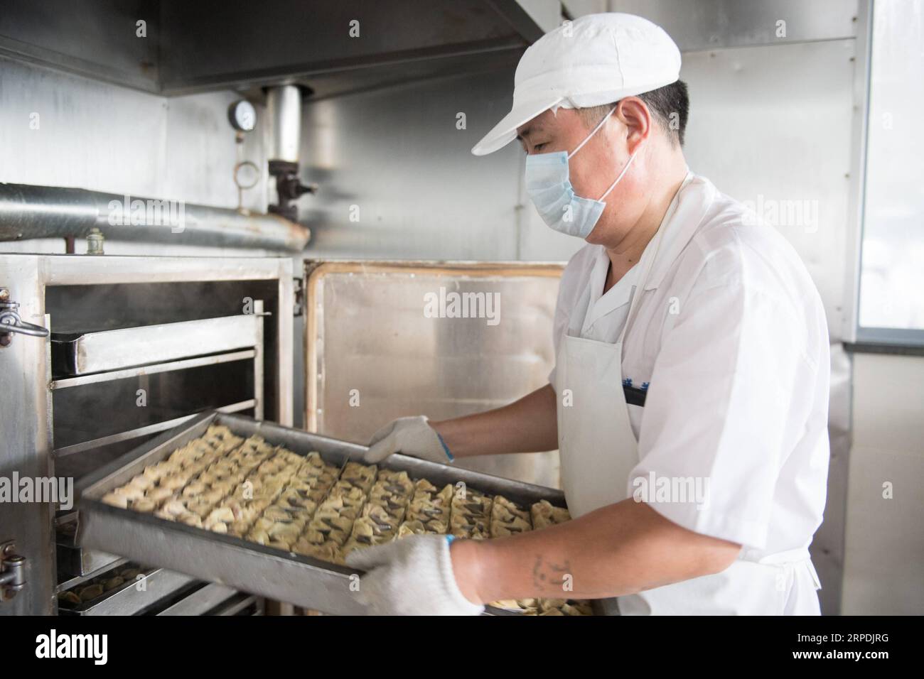 (190806) -- HUZHOU, 6. August 2019 -- Ein Mitarbeiter trägt gedämpfte Brötchen, ein traditionelles chinesisches Essen der Marke Dinglianfang, im Wuxing-Bezirk von Huzhou, ostchinesische Provinz Zhejiang, 6. August 2019. Die chinesische Marke Dinglianfang wurde in der Zeit Guangxus (1875-1908) der Qing-Dynastie gegründet. Sie hat eine Reihe von unverwechselbaren Lebensmitteln entwickelt und sich auch auf dem Online-Markt engagiert. ) CHINA-ZHEJIANG-HUZHOU-DINGLIANFANG-TIME-HONORED BRAND (CN) WENGXXINYANG PUBLICATIONXNOTXINXCHN Stockfoto