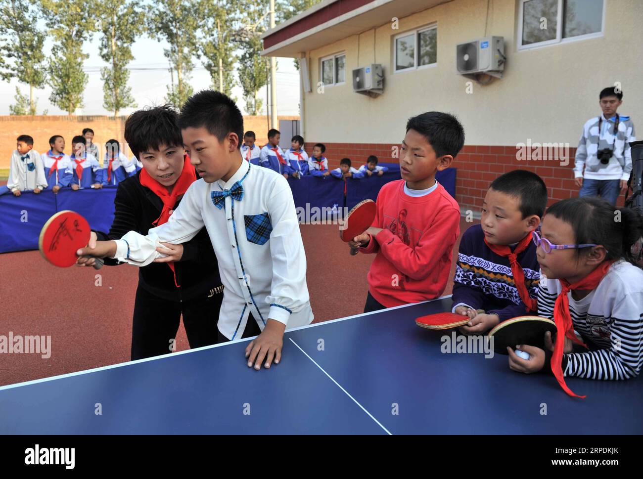 (190806) -- Peking, 6. August 2019 -- Deng Yaping(1. L) weist Schüler der Huangchenggen-Grundschule an, Tischtennis in Peking, der Hauptstadt Chinas, am 17. Oktober 2014 zu spielen. Seit der Gründung der Volksrepublik China haben sich Berufssport und nationale Fitness in Abstimmung entwickelt, um gemeinsam den Wohlstand des Sports zu fördern. ) (SP)CHINA-PEKING-70 JAHRE GRÜNDUNG DER VR CHINA-CHINESISCHE SPORTGESCHICHTE-PROFI-SPORT-NATIONALE FITNESS LIXWEN PUBLICATIONXNOTXINXCHN Stockfoto