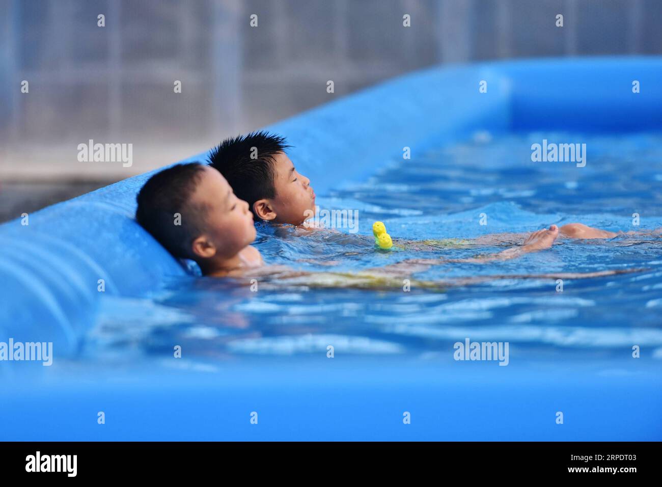 (190811) -- ANYI, 11. August 2019 -- zwei Jungen ruhen sich in einem Schwimmbad im Dorf Shuinan, Kreis Anyi, ostchinesische Provinz Jiangxi, 8. August 2019. Die Dörfer Luotian, Shuinan und Jingtai im Anyi County haben jeweils eine über 1.400-jährige Geschichte. Sie haben zusammen mehr als 120 intakte alte Herrenhäuser aus den Ming- und Qing-Dynastien (1368–1912). Dank integrierter Planung und effektivem Management sind sie heute beliebte Touristenattraktionen, basierend auf dem Gewicht der Geschichte und der einzigartigen Gan-Kultur. 2018 wurden in den drei alten Dörfern mehr als 200.000 Besucher empfangen. CHINA-JIANGXI-ANYI-TOURISM (CN) LIXMA Stockfoto