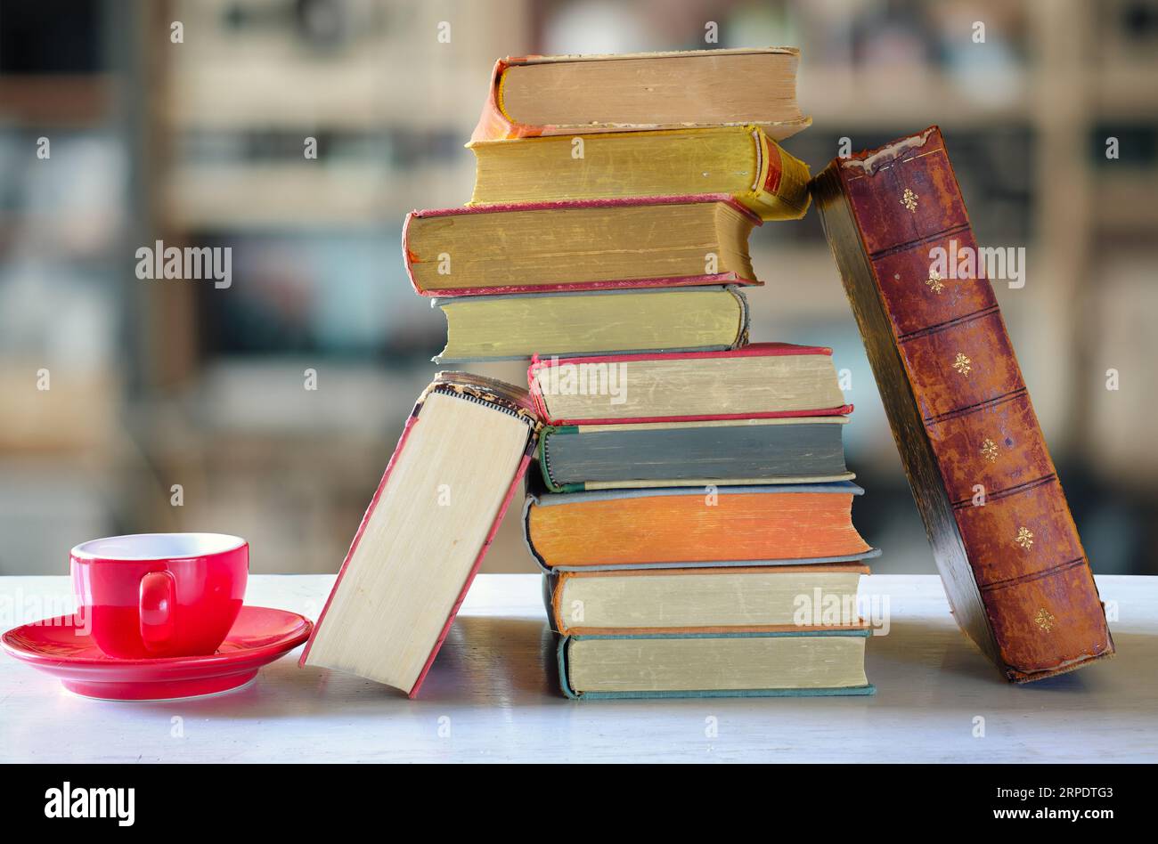 Stapel von Büchern mit verschwommenem Buchregal-Hintergrund, Buchmesse, Entspannung, Lesen, Lernen, Bildung oder Home Office-Konzept Stockfoto