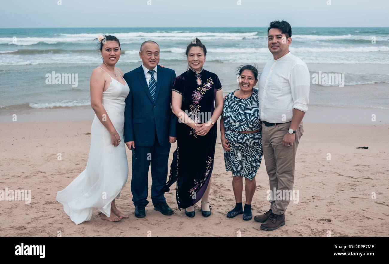 (190820) -- HAIKOU, 20. August 2019 -- Hebert Vasquez (1. R) aus El Salvador und seine Frau Tong Taohui (1. L) posieren mit ihren Familienmitgliedern bei ihrer Hochzeitszeremonie in Qionghai, Provinz Hainan, 5. Mai 2019. Hebert Vasquez, 42, Postdoktorand aus El Salvador, verliebte sich in ein chinesisches Mädchen Tong Taohui, als er 2011 seinen Doktor in Japan machte. Nach seinem Abschluss im Jahr 2016 entschied sich Hebert, nach China zu kommen. China und El Salvador haben am 21. August 2018 diplomatische Beziehungen aufgenommen. Seit der Aufnahme diplomatischer Beziehungen, m Stockfoto