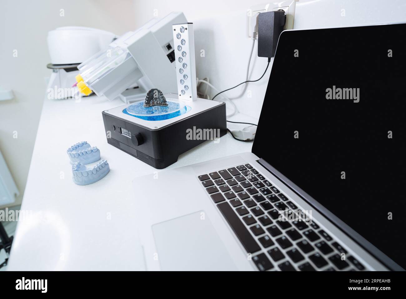 Laptop und Gerät zum Waschen eines Dental 3D Prints in einer Reinigungslösung und zum Aushärten der Form mit UV-Licht. Stockfoto