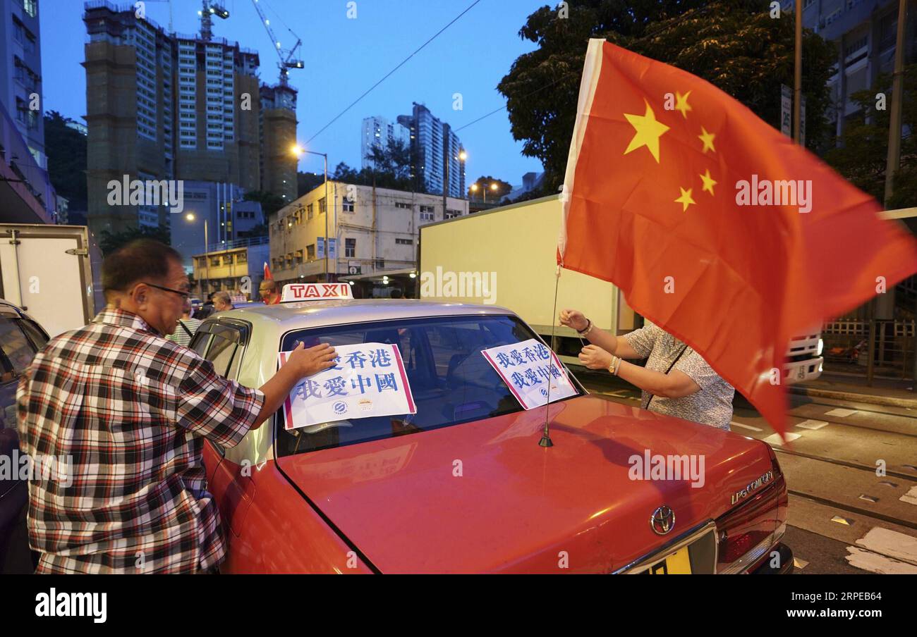 (190824) -- HONG KONG, 24. August 2019 -- Ein Mann hängt Ein Poster mit der Aufschrift I Love Hong Kong an. Ich liebe China. Zu einem Taxi während einer friedlichen Kundgebung in Hongkong, Südchina, 23. August 2019. Fast 600 Taxis nahmen am Freitag an einer Friedensdemonstration gegen Gewalt Teil und zeigten den Einwohnern Hongkongs die Liebe zu ihrem Zuhause und dem Mutterland. Die von der Bürgergruppe Safeguard Hong Kong and Hong Kong Taxi Drivers and Operators Association organisierte Kundgebung zielte darauf ab, die Hongkonger Gemeinschaft zu drängen, sich gemeinsam gegen Gewalt zu stellen und die soziale Ordnung so schnell wie möglich wiederherzustellen, so die Organisatoren. CHINA-HONGKONG-TAXIS R Stockfoto