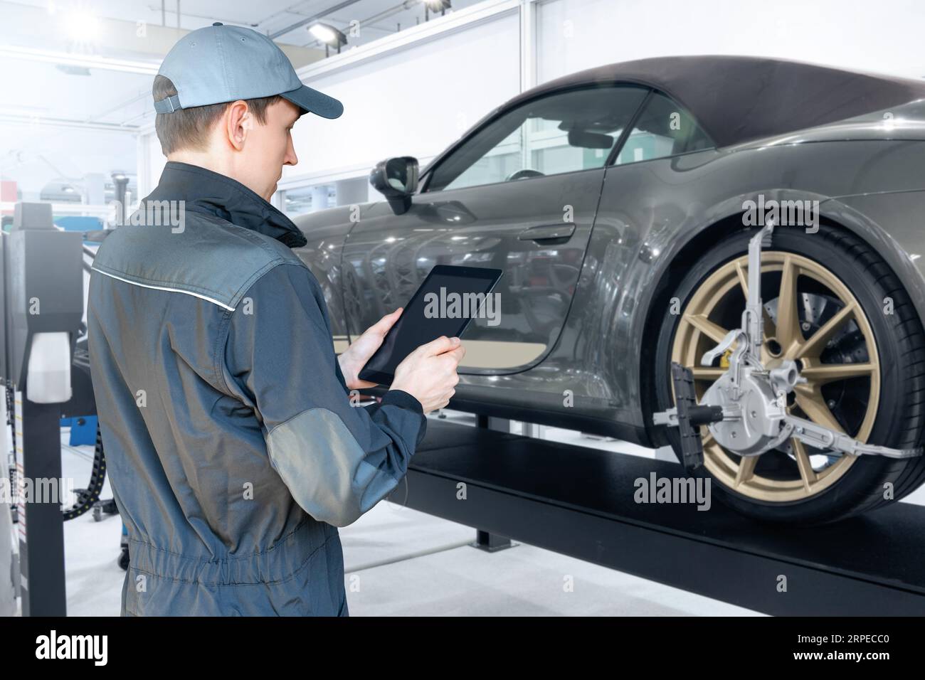 Servicemänner mit digitalem Tablet auf dem Hintergrund des Autos im Autodienst. Stockfoto
