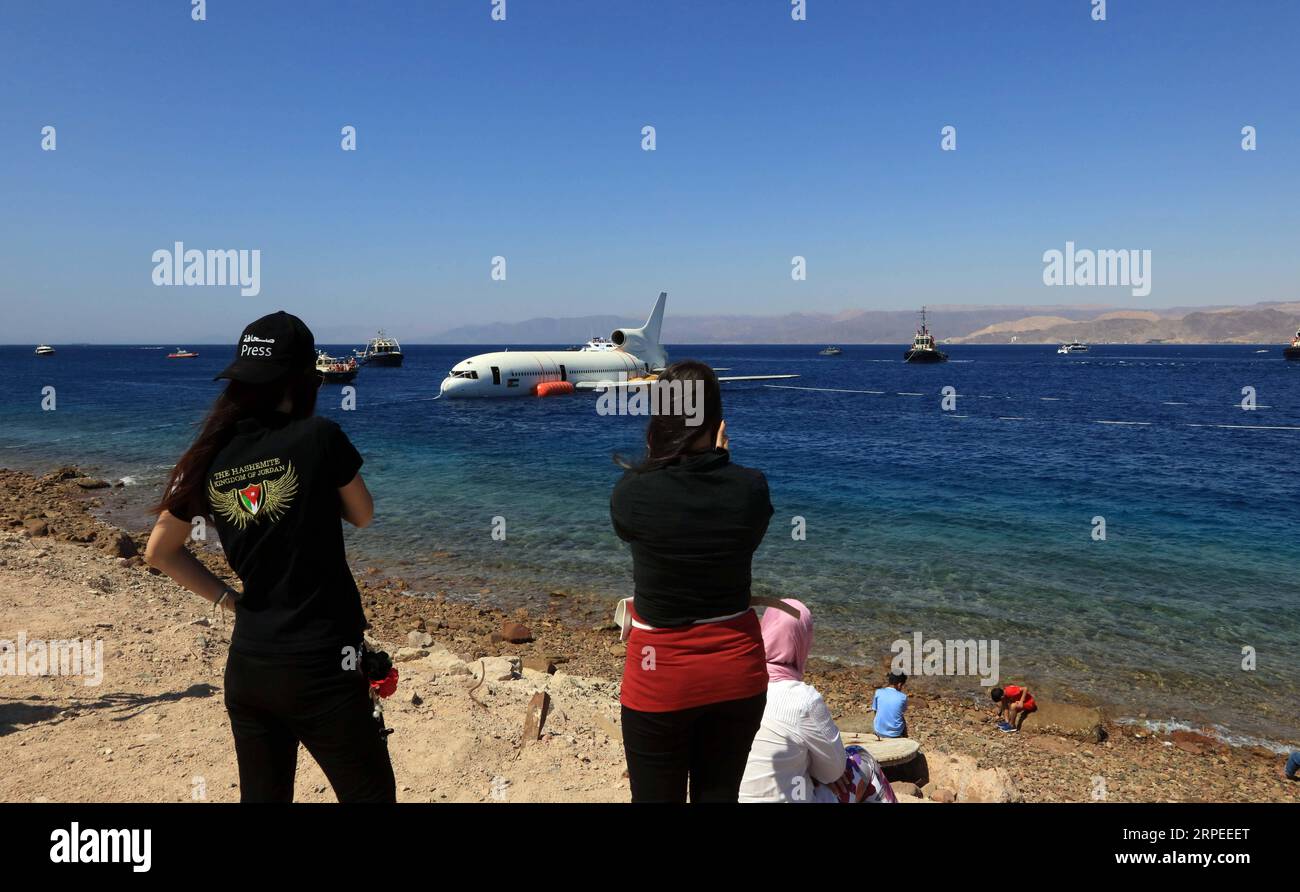 (190826) -- AQABA (JORDANIEN), 26. August 2019 -- Menschen beobachten, wie ein Lockheed L-1011 Tristar-Flugzeug am 26. August 2019 im Roten Meer in Aqaba, Jordanien, untergetaucht wird. Die Aqaba Special Economic Zone Authority (ASEZA) in Jordanien versenkte am Montag ein stillgelegtes Verkehrsflugzeug in die Unterwassermuseum-Tauchstätte von Aqaba, um die Meereslebewesen zu stärken. (Foto von /Xinhua) JORDAN-AQABA-RED MEER-UNTERWASSER-MUSEUMSFLUGZEUG, DAS MohammadxAbuxGhosh PUBLICATIONxNOTxINxCHN UNTERTAUCHT Stockfoto