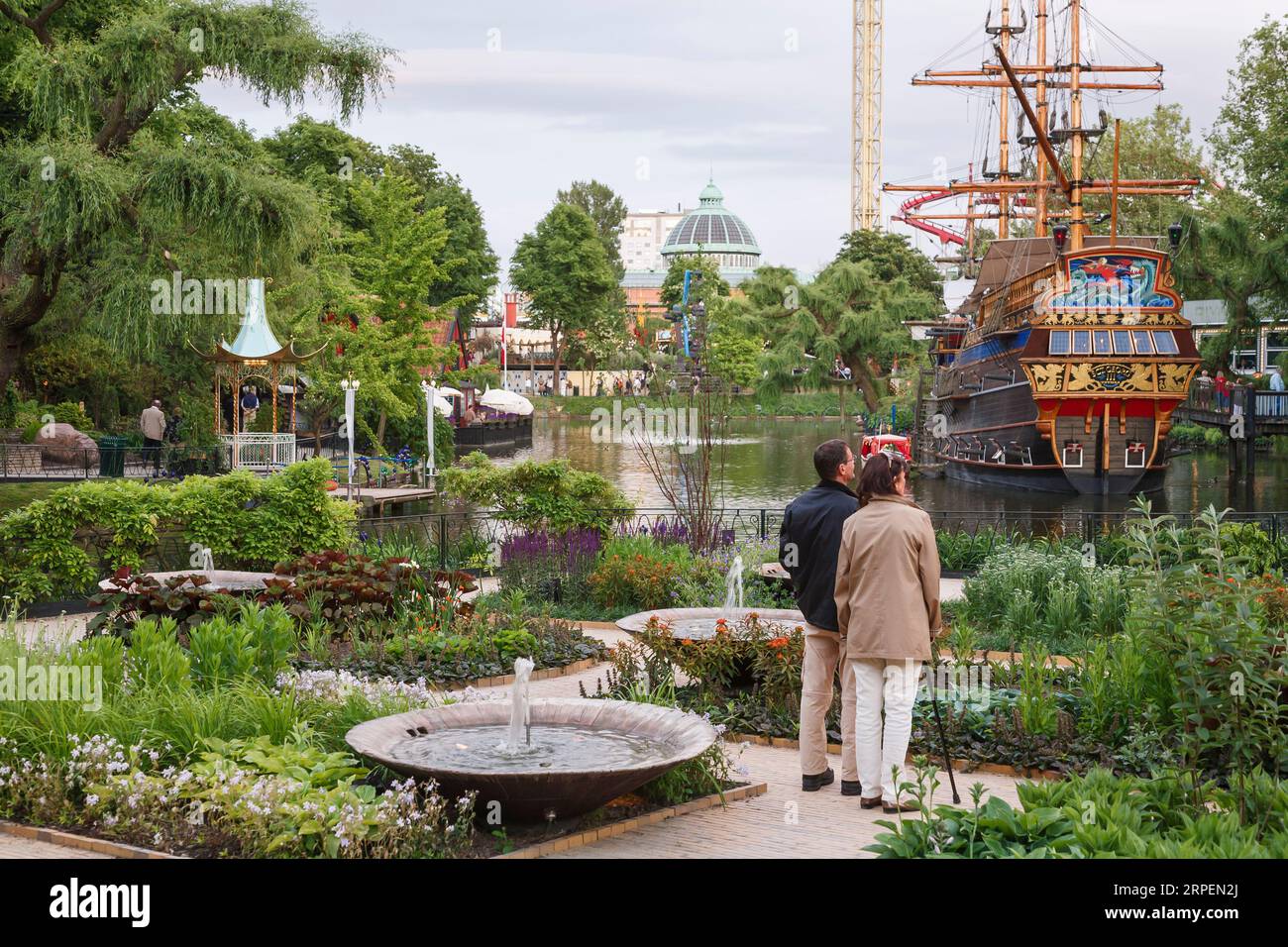 KOPENHAGEN, DÄNEMARK - 17. Juni 2006. Reifes Paar besucht Tivoli Gärten mit See und Piratenschiff. Kopenhagen, Dänemark. Stockfoto