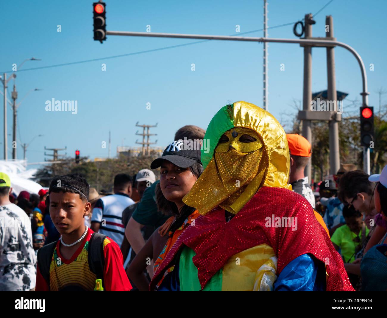 Barranquilla, Atlantico, Kolumbien - 18. Februar 2023: Kolumbianische Frau in einem bunten Kostüm schaut mit anderen jungen Menschen auf die Kamera Stockfoto