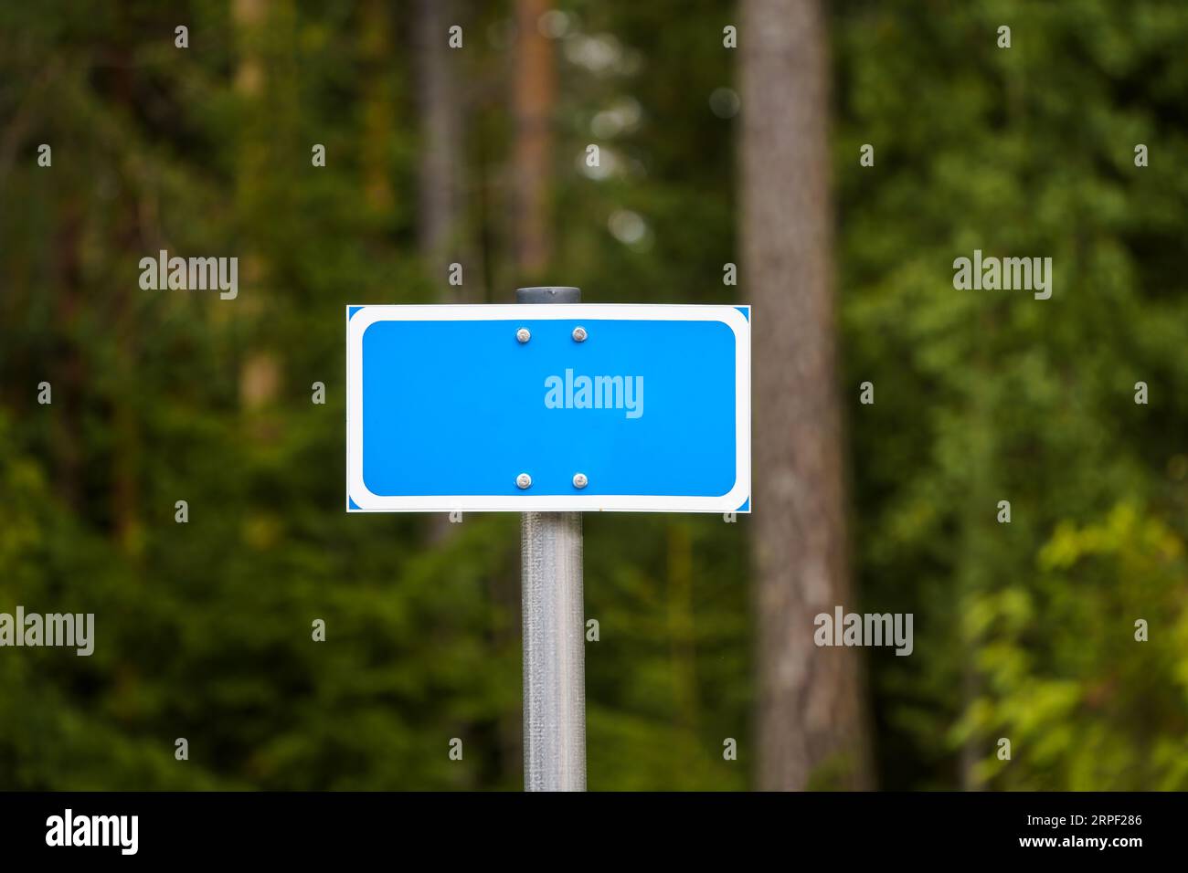Leeres blaues Verkehrszeichen vor dem Waldhintergrund in finnland. Stockfoto