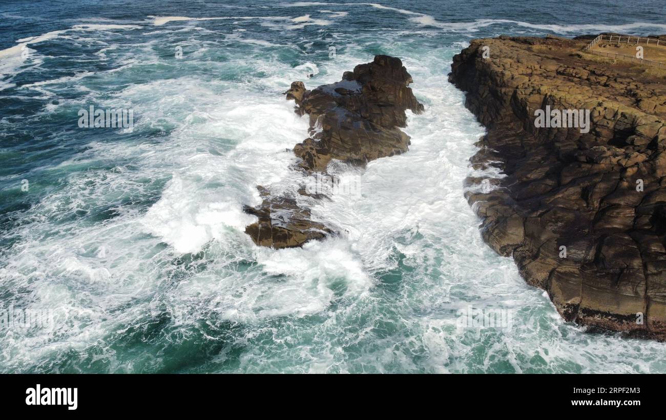 Luftaufnahme von Wellen, die in der Boiler Bay an der Küste von Oregon abstürzen. Stockfoto