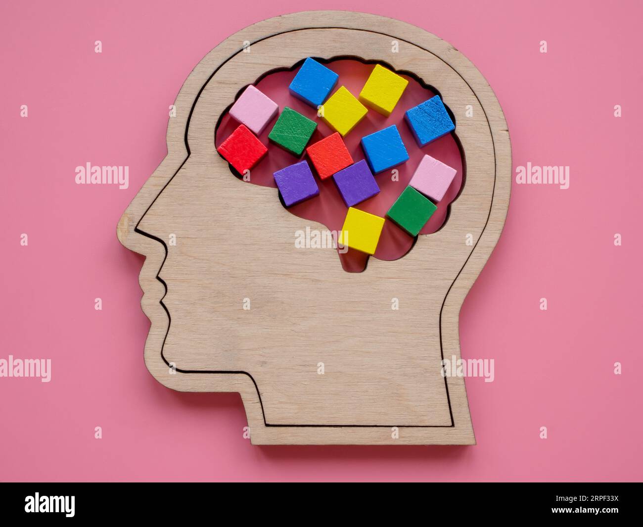 Kopfform und bunte Würfel als Symbol für Neurodiversität oder Kreativität. Stockfoto