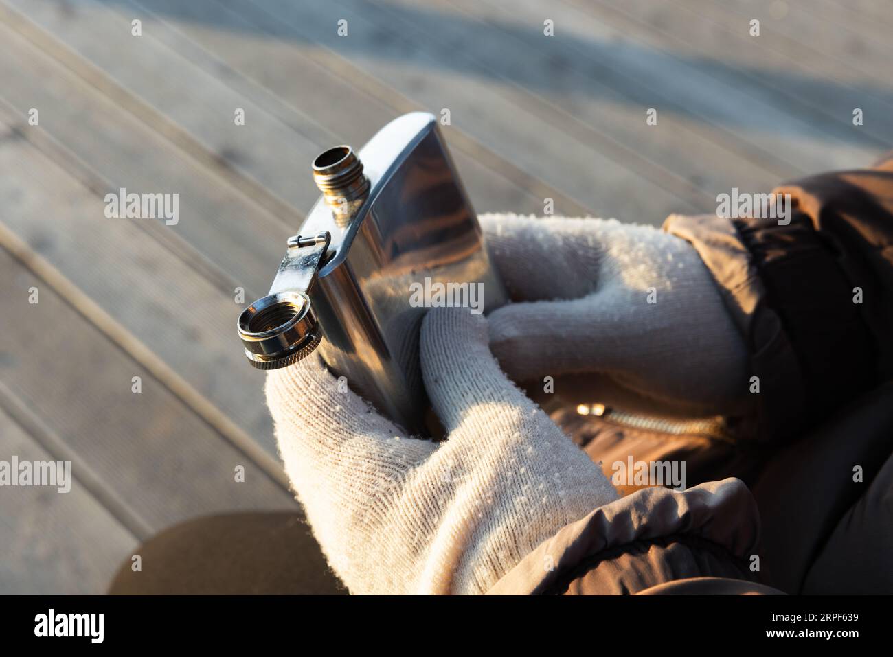 Glänzender Taschenkolben aus Stahl in den Händen, Außenfoto mit selektivem Fokus Stockfoto