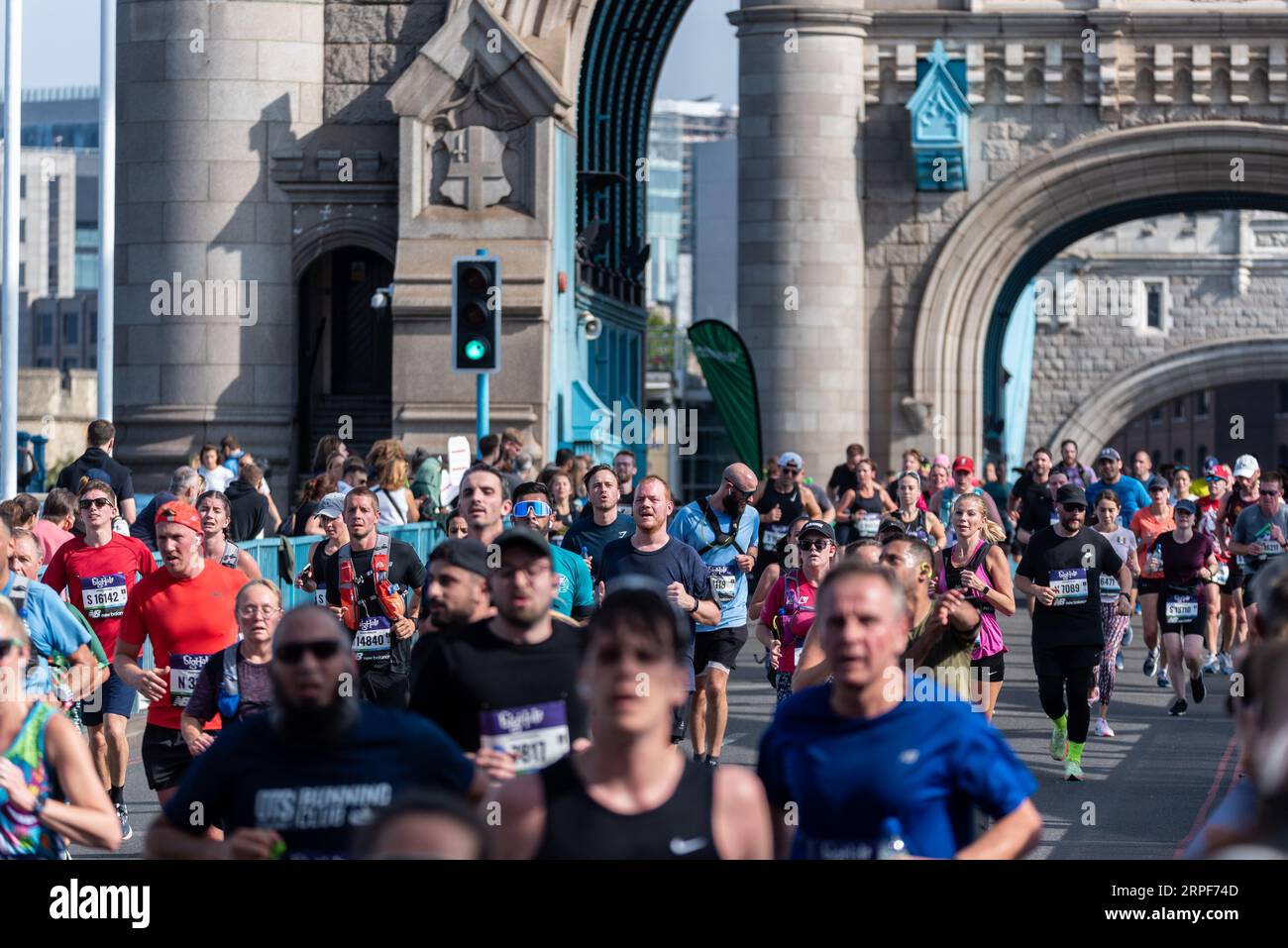 Lustige Läufer, die am Big Half, einem Halbmarathon, teilnehmen, der von London Marathon Events organisiert wird und in Tower Hamlets beginnt, die die Tower Bridge überqueren. Stockfoto