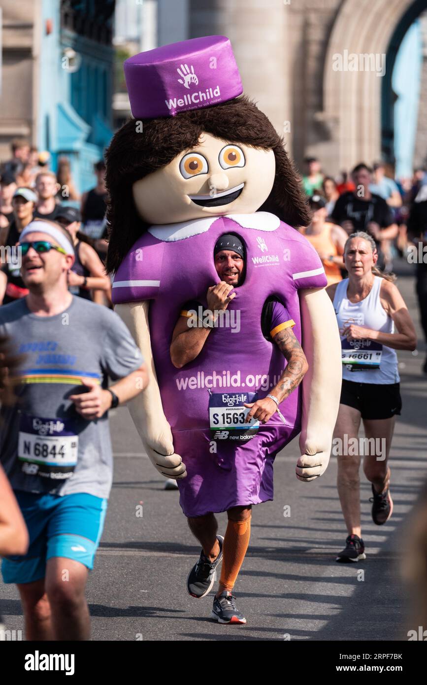 James Prosser, der beim Big Half, einem Halbmarathon, der von London Marathon Events organisiert wird, in WellChild Nurse Kostüm über die Tower Bridge tritt. Stockfoto