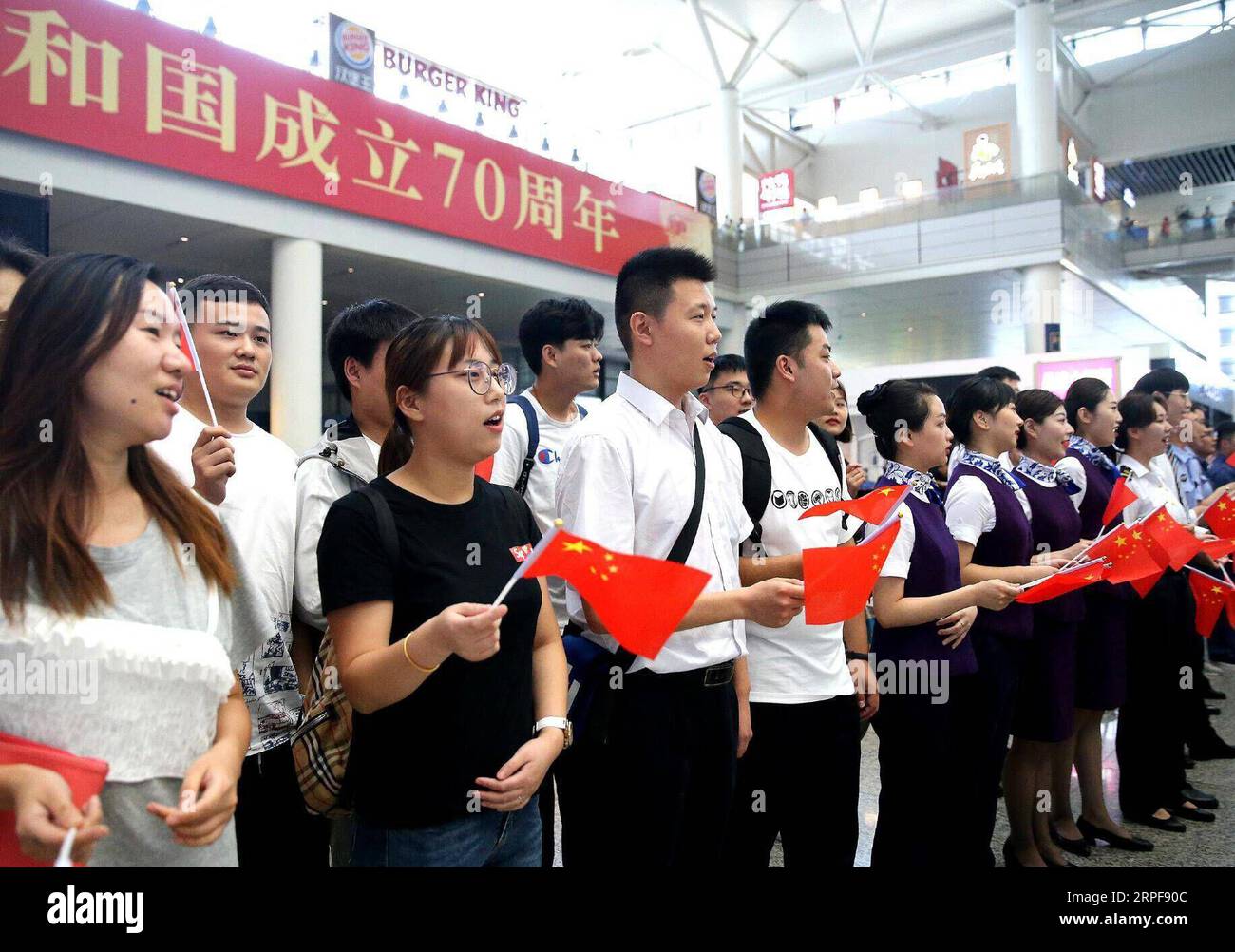 (190917) -- SHANGHAI, 17. September 2019 -- Passagiere und Mitarbeiter des Bahnhofs Shanghai Hongqiao nehmen an einem Flashmob im ostchinesischen Shanghai, 17. September 2019, Teil. Die Teilnehmer chorten patriotische Lieder während des Flashmobs, um den 70. Jahrestag der Gründung der Volksrepublik China zu feiern. CHINA-SHANGHAI-FLASH MOB-CHORUS (CN) CHENXFEI PUBLICATIONXNOTXINXCHN Stockfoto