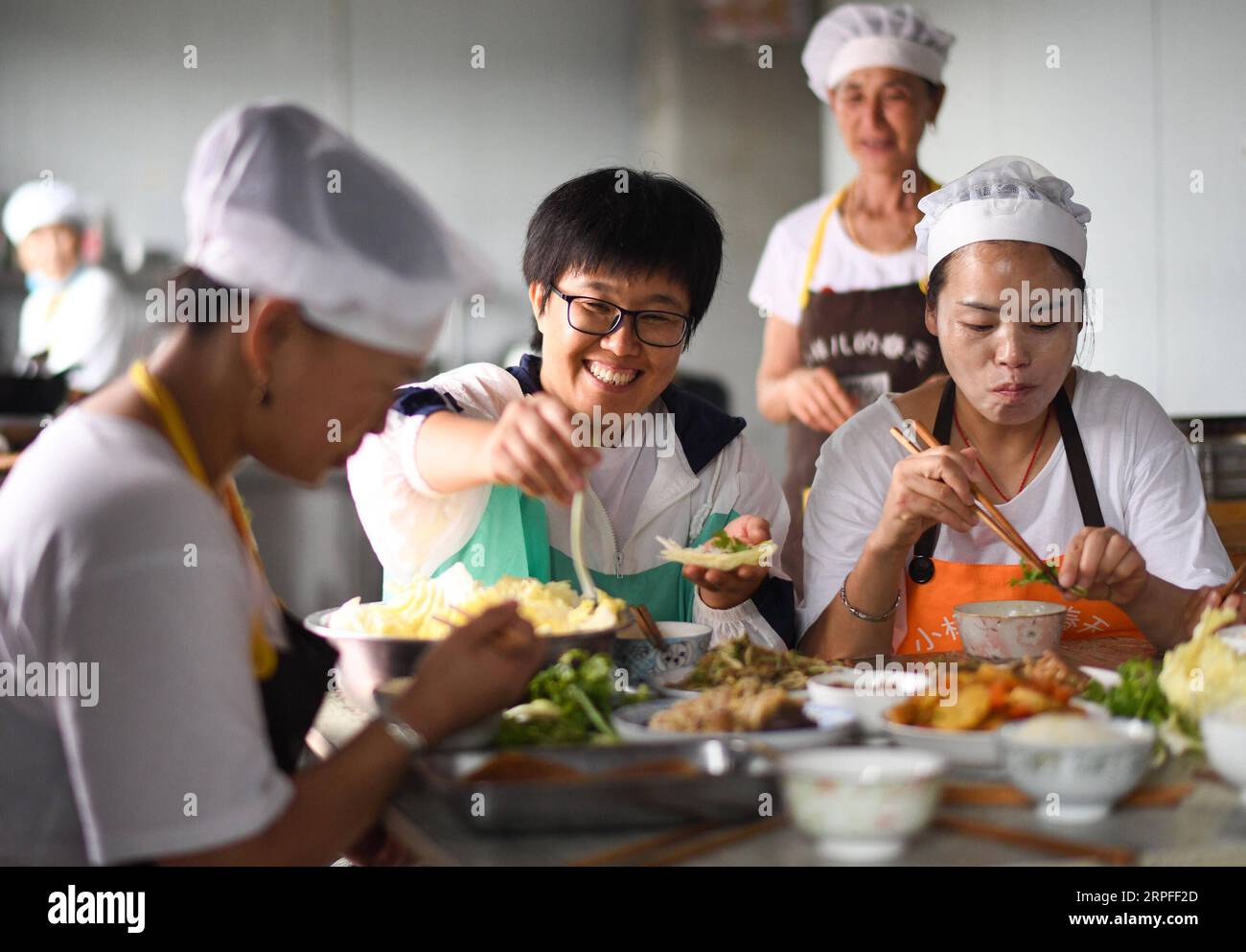 190923 -- PEKING, 23. September 2019 -- Li Chencan C und Arbeiter essen in einem Workshop im Dorf Xingbei der Gemeinde Wanfa im Bayan County, nordöstliche Provinz Heilongjiang, 30. August 2019. Li Chencan, eine in den 1980er Jahren im Dorf Xingbei geborene Landwirtin, eröffnete 2014 mit Hilfe ihrer Familienmitglieder einen Online-Shop, um landwirtschaftliche Produkte aus Nordostchina zu verkaufen. Um den Online-Markt zu erweitern, lernte Li nicht nur die Methoden des Betriebs und der Pflege von Online-Shops selbst kennen, sondern stellte auch lokale Landwirte ein, um den Shop besser zu verwalten und Verträge mit verarmten Haushalten abzuschließen Stockfoto