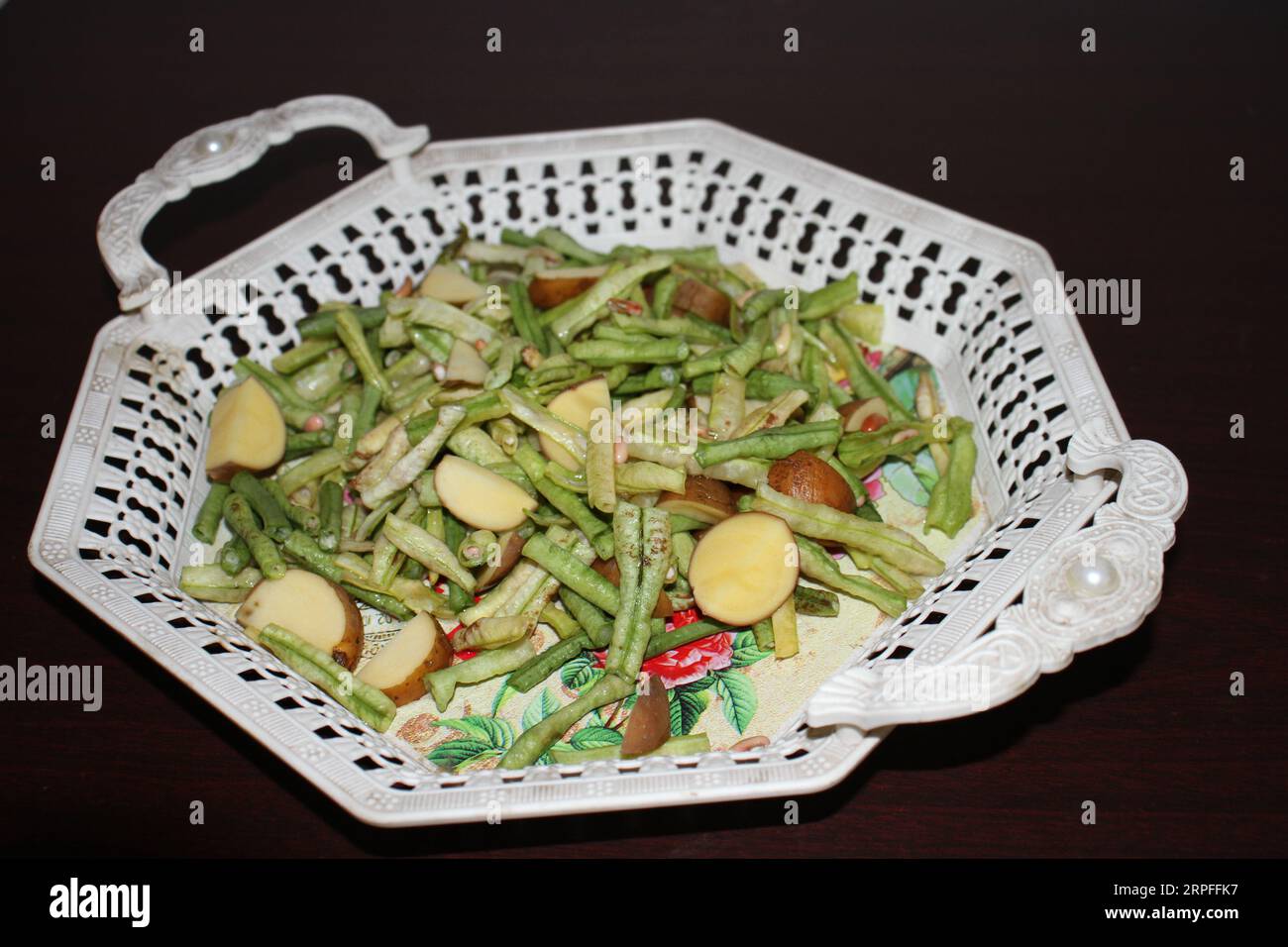 Ein Teller mit grünen Bohnen und Kartoffeln. Stockfoto