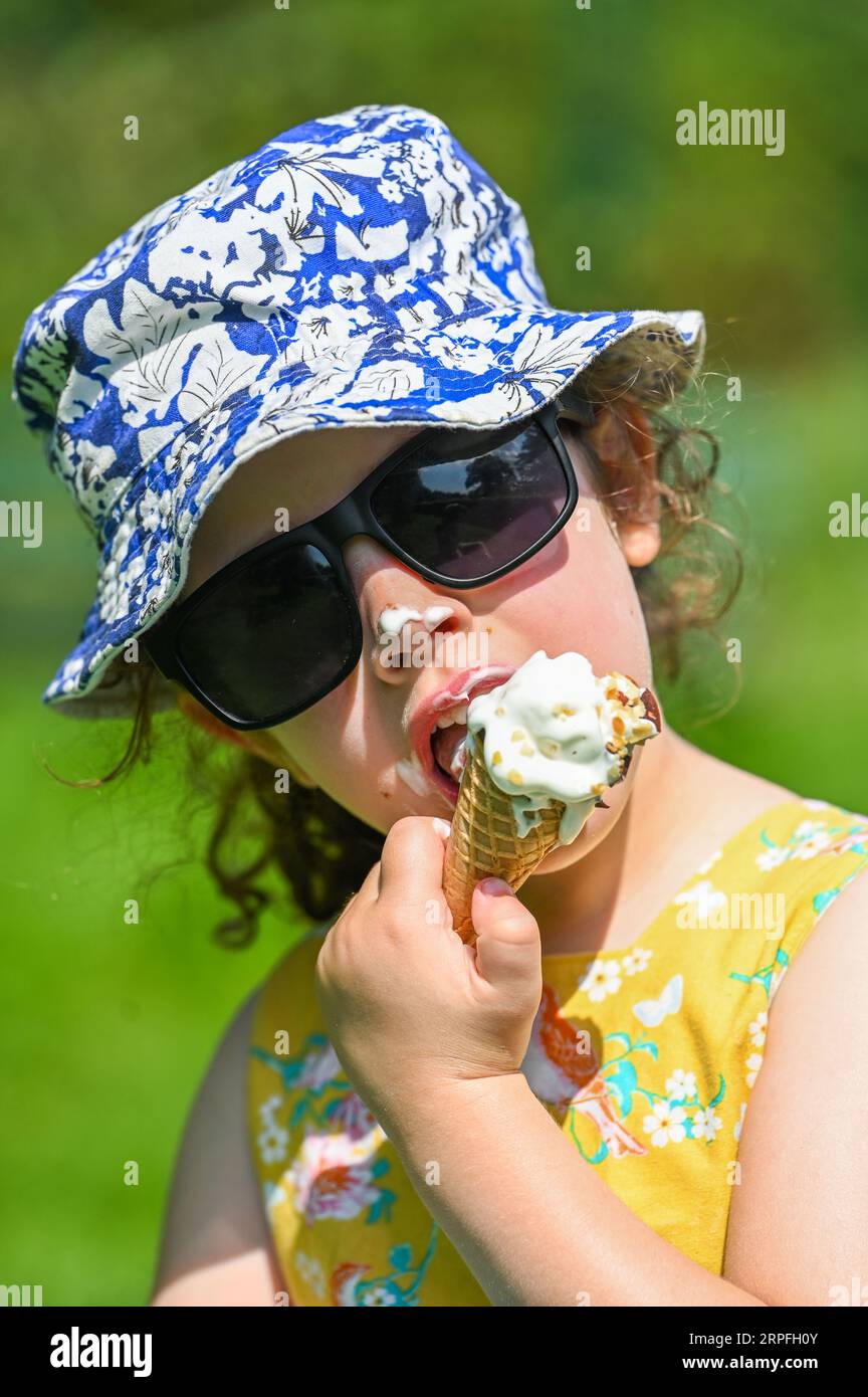 Lillian Joy im Alter von fünf Jahren genießt ein Eis in Swansea, während die Temperaturen in ganz Großbritannien steigen und die Menschen endlich warmes Sommerwetter genießen. Stockfoto