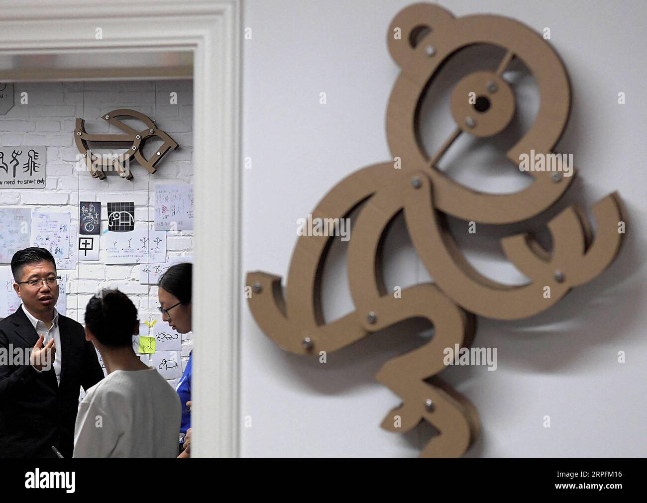 190927 -- PEKING, 27. September 2019 -- Chen Nan 1st L und seine Teammitglieder diskutieren ein Design-Schema von oracle Bone Script in seinem Studio in der Tsinghua Universität in Peking, Hauptstadt von China, 24. September 2019. Mit einer Geschichte von mehr als 3.000 Jahren hat oracle Bone Script, die frühesten chinesischen Schreibinschriften, die auf Schildkrötenschalen und Tierscapulas gemeißelt wurden, dank der Bemühungen von Chen Nan moderne Bedeutungen mit einer neuen Reihe von Emojis erhalten. Chen, ein Professor an der Akademie der Künste und des Designs der Tsinghua Universität, hat sich dem Studium und dem Design von oracle Bone Script Sin gewidmet Stockfoto
