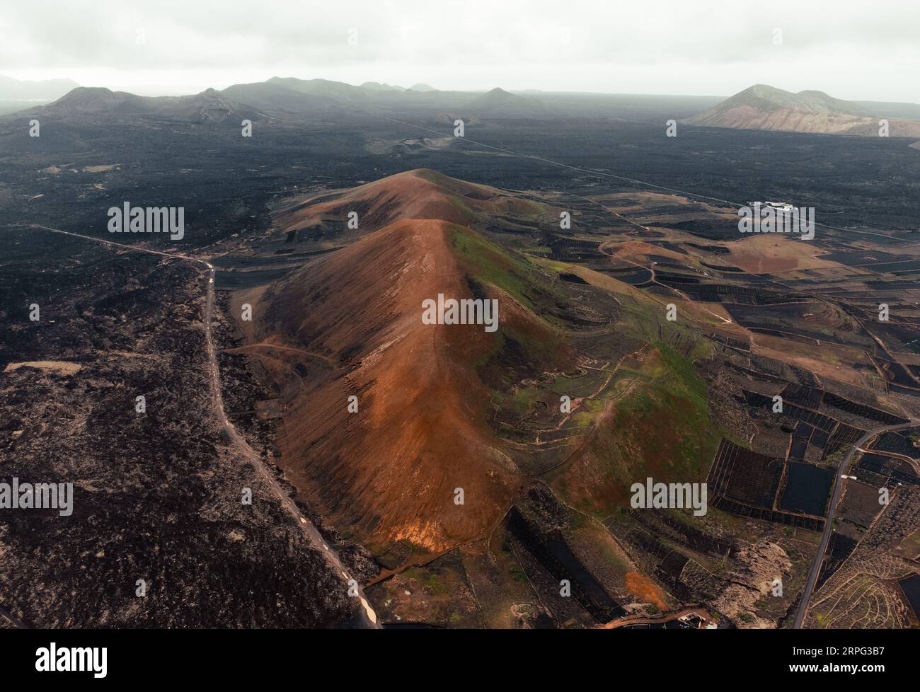 Luftbild von Vulkanen auf Lanzarote - Kanarische Inseln. Foto von vulkanischen dunklen Bergen und Kratern aus großer Höhe mit Drohne. Wunderschöne Landschaft Stockfoto