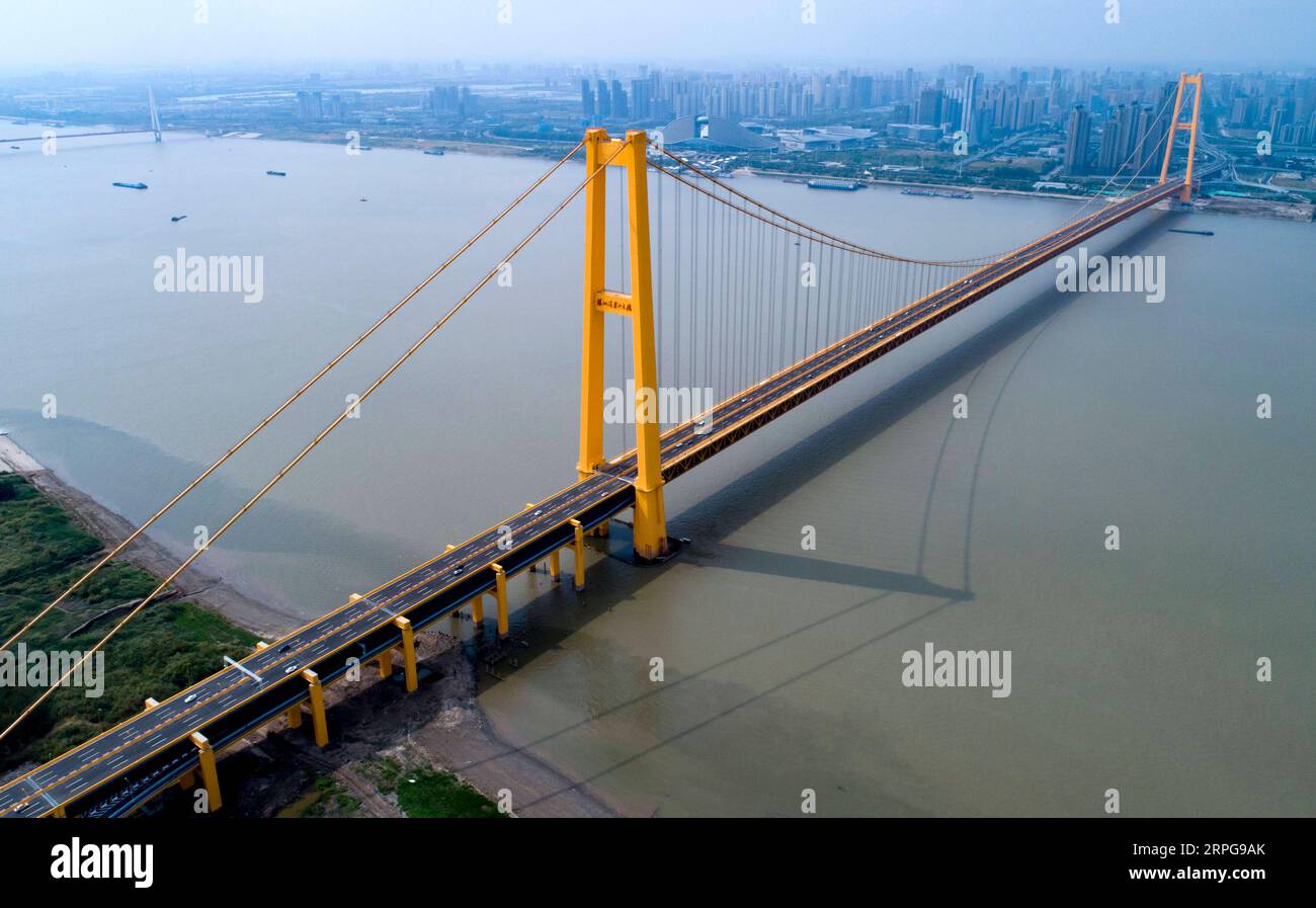 191008 -- WUHAN, 8. Oktober 2019 -- Luftaufnahme, aufgenommen am 8. Oktober 2019, zeigt die Yangsigang Yangtze River Brücke nach der Eröffnung von Taffic in Wuhan, der Hauptstadt der zentralchinesischen Provinz Hubei. Die zweistöckige Hängebrücke mit der längsten Spannweite der Welt wurde am 8. Oktober in Wuhan für den Verkehr geöffnet. Die zweistöckige Straßenbrücke über den Yangtze mit einer 1.700 Meter langen Hauptspannweite erstreckt sich über 4,13 km Gesamtlänge. Das Oberdeck der 10. Yangtze River Bridge hat sechs Fahrspuren mit einer geplanten Geschwindigkeit von 80 km/h, während das Unterdeck auch sechs Fahrspuren mit einer geplanten Geschwindigkeit von 60 km/h hat. CHINA-HUBEI-W Stockfoto