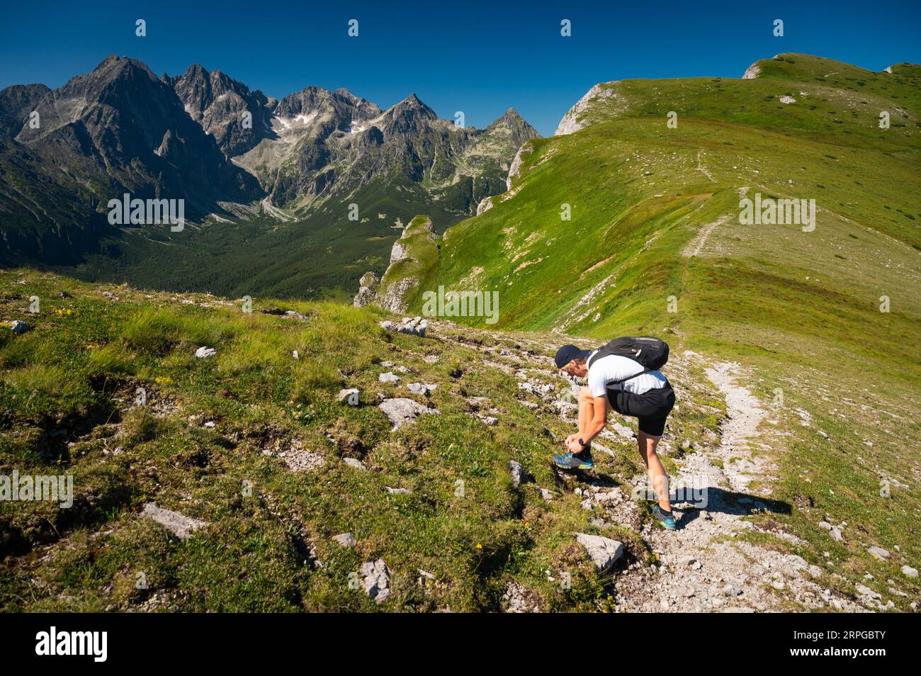 Junge Wanderer halten für eine Weile auf der Wanderung in der Hohen Tatra. Wunderschöne Landschaft im Hintergrund Stockfoto