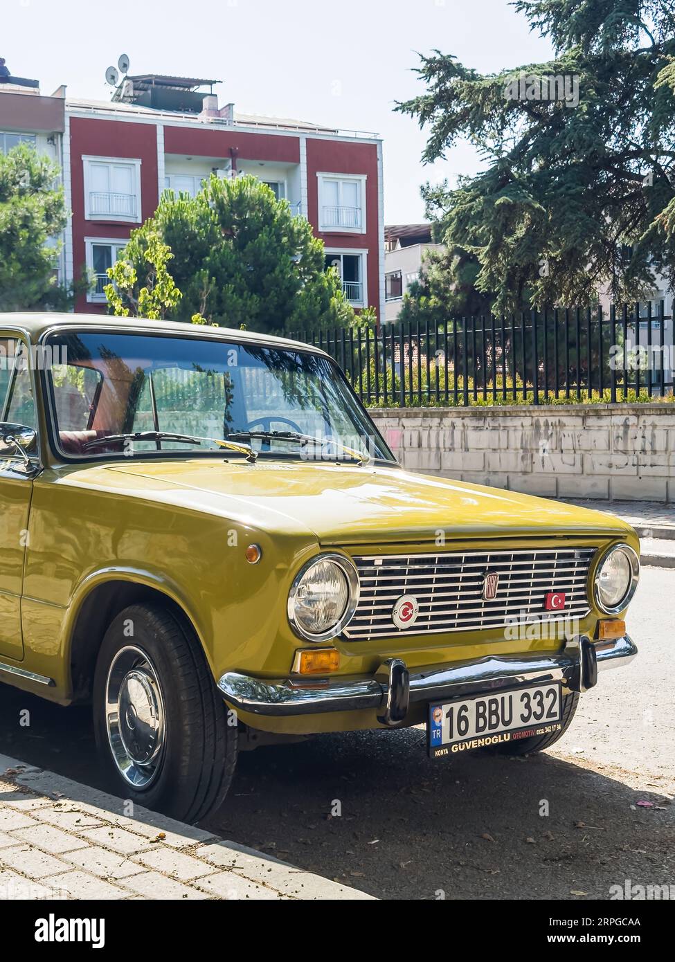 Gelber Oldtimer auf der Straße geparkt, perfekter Zustand, klassischer FIAT 124. Hochwertige Fotos Stockfoto