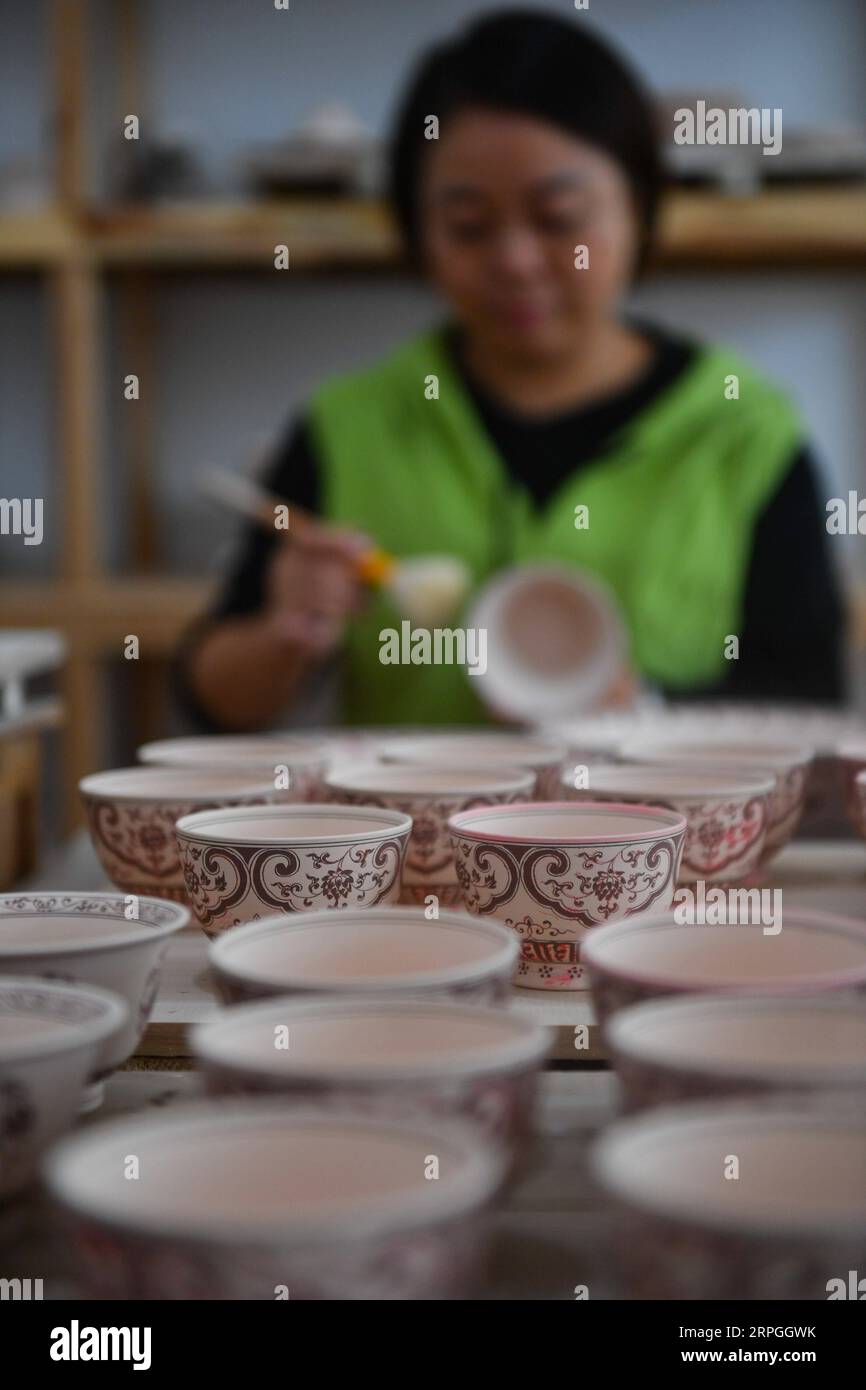 191016 -- NANCHANG, 16. Oktober 2019 -- Ein Mitglied des Teams Kuaixueshiqing staubt Porzellanwerke in Jingdezhen, ostchinesische Provinz Jiangxi, 15. Oktober 2019. Eierschalenporzellan, eine berühmte Art traditionelles Porzellan, das in Jingdezhen von Jiangxi hergestellt wird, ist berühmt für seinen dünnen und transparenten Körper, der es zu etwas Besonderem macht. Wang Minhui, 40, ist Leiter des Porzellanherstellungsteams für Eierschalen, Kuaixueshiqing. Wang und seine beiden Partner du Xingyu und Liu Zhen, die sich für Porzellan interessieren, gründeten das Team 2010. Das Team, das mittlerweile über 20 Mitglieder hat, hat darauf bestanden, Perfektion zu erreichen Stockfoto