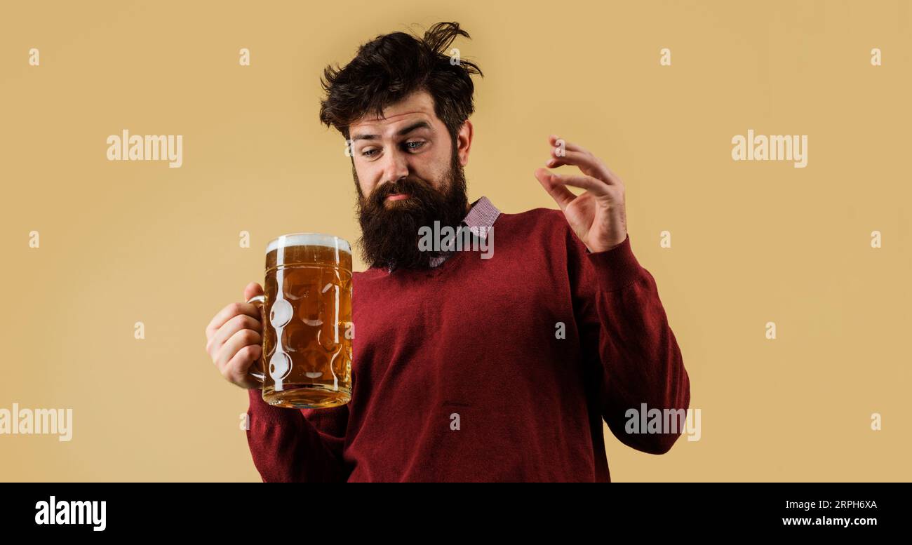 Oktoberfestfest. Alkohol. Betrunkener Mann mit einem Glas Bier. Bärtiger Hipster, der frisch gebrautes Bier verkostet. Bierbrauer mit einer Tasse Craft-Bier Stockfoto