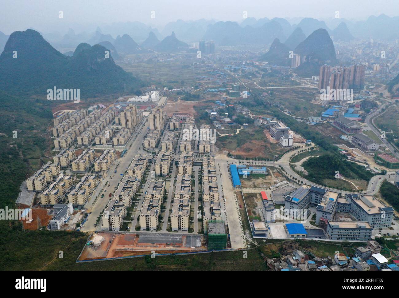 191107 -- LUOCHENG, 7. Nov. 2019 -- Luftaufnahme vom 6. Nov. 2019 zeigt einen Blick auf ein Umzugsgebiet und seine unterstützenden Einrichtungen für Mulao-Ethnien im Luocheng County, der südchinesischen autonomen Region Guangxi Zhuang. Wu Caizhong ist ein 36-jähriger Mulao-Ethnie. Seine Familie lebte zusammen mit anderen Mulao-Völkern in Xiayantun im Dorf Mianhua, einem Dorf, das aufgrund der karstigen Wüstenbildung und der schlechten Verkehrsbedingungen von unzureichender Entwicklung betroffen war. Im Juni 2018 wurden Wus Familie und andere Dorfbewohner in ein neues Wohngebiet für Mulao-Ethnien in Luoche verlegt Stockfoto