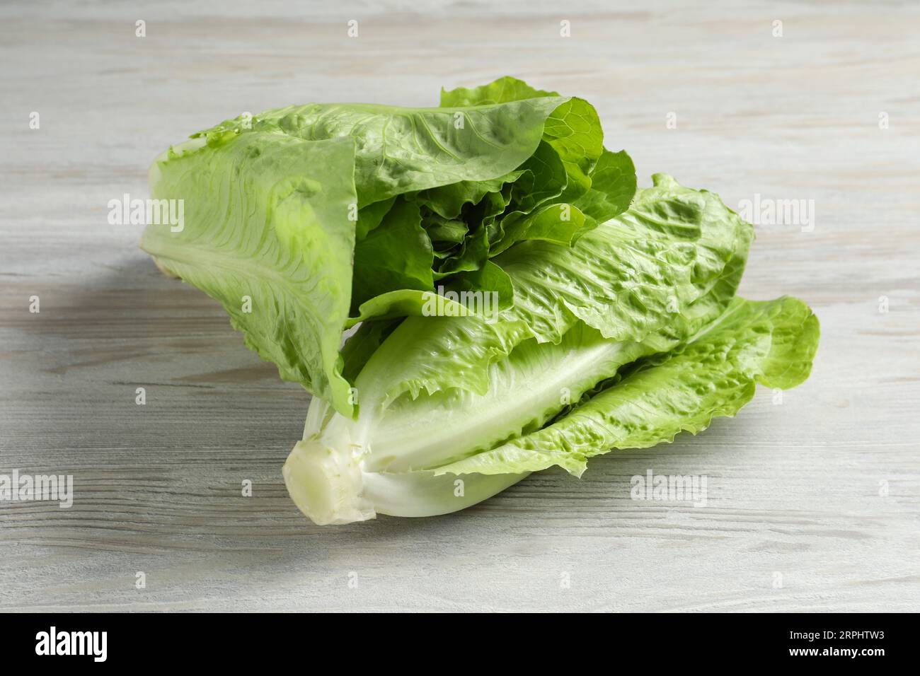 Frische grüne Romaine-Salate auf weißem Holztisch Stockfoto