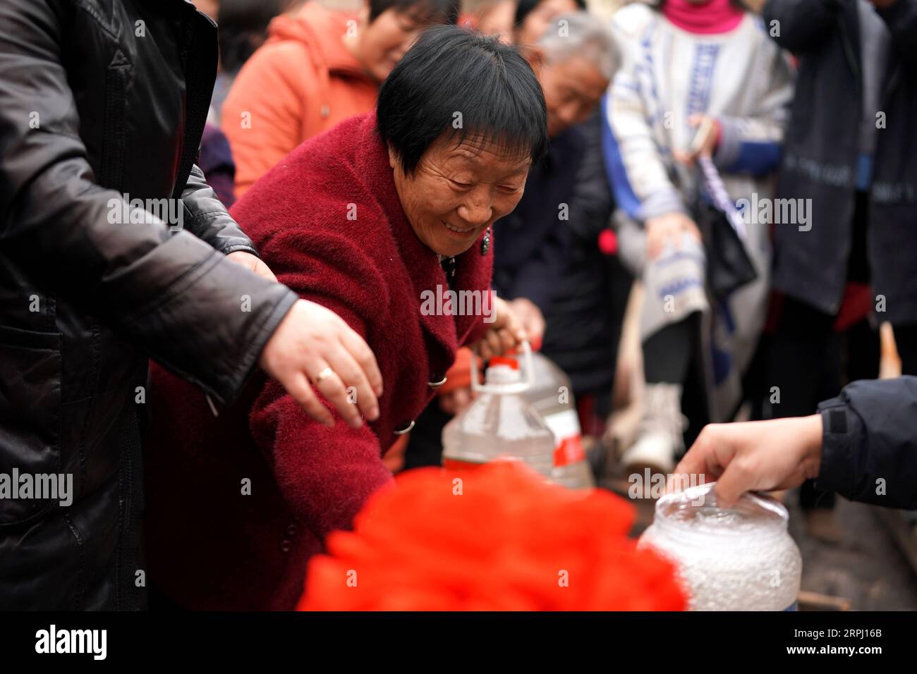 191122 -- YICHENG COUNTY, 22. November 2019 -- Dorfbewohner sammeln Wasser, nachdem ein Tiefwasserbrunnen begonnen hat, unterirdisches Wasser im Nanling Village im Yicheng County, 20. November 2019 zu pumpen. Als der Schalter gezogen wurde, sprang Wasser aus 403 Metern Tiefe heraus. Nanling Village's allererster Tiefwasserbrunnen wurde an einem frühen Wintermorgen in Betrieb genommen. In der Vergangenheit hatte sich das Dorf, das sich über die Schluchten des Zhongtiao-Gebirges im Norden Chinas ausbreitete, jahrhundertelang ausschließlich auf Schlammgruben verlassen, um sein wertvolles Trinkwasser zu speichern. Von der Angst vor der Dürre heimgesucht, hatten Generationen von direktem Zugang geträumt Stockfoto