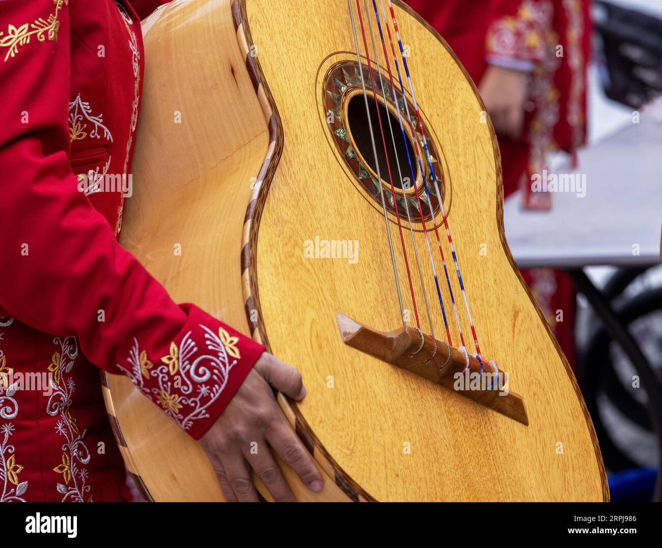 Nahaufnahme einer nicht erkennbaren Mariachi-Frau in traditionellem Charra-Kostüm mit einem Mariachi Guitarrón Mexicano (große mexikanische Gitarre) Stockfoto