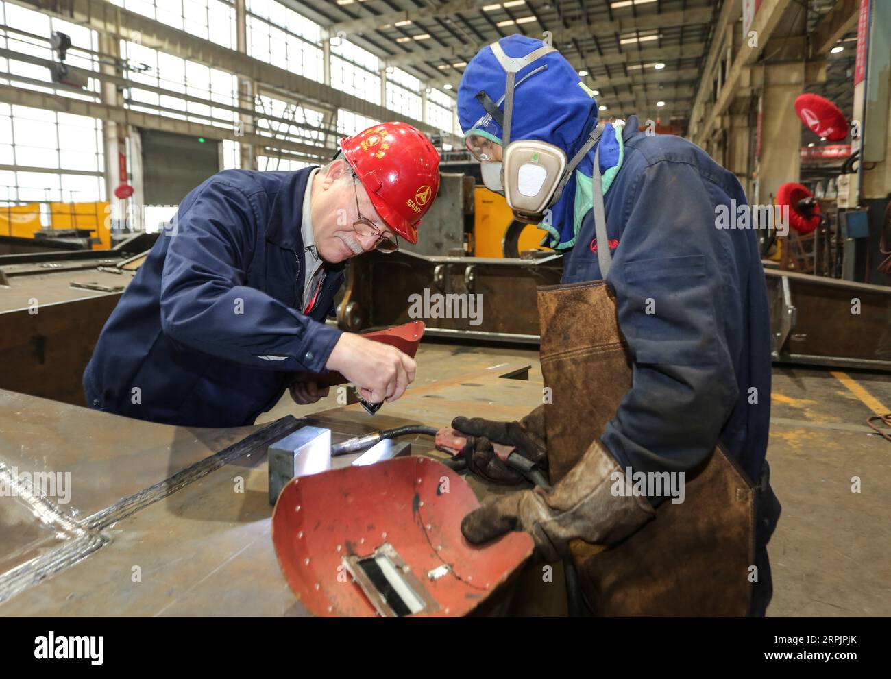 191217 -- HUZHOU, 17. Dezember 2019 -- James Joseph Hoffman, ein leitender Ingenieur aus den Vereinigten Staaten, hilft seinem Mitarbeiter, Schweißfertigkeiten bei der Zhejiang Sany Heavy Industry Co., Ltd. In Huzhou City, ostchinesische Provinz Zhejiang, am 17. Dezember 2019 zu verbessern. Der Bezirk Wuxing der Stadt Huzhou in der ostchinesischen Provinz Zhejiang hat offenere, vielfältigere und marktorientiertere Mittel erforscht, um externe Talente für eine bessere und schnellere Entwicklung der Stadt anzuziehen. CHINA-ZHEJIANG-HUZHOU-AMERIKANISCHER INGENIEUR CN XUXYU PUBLICATIONXNOTXINXCHN Stockfoto