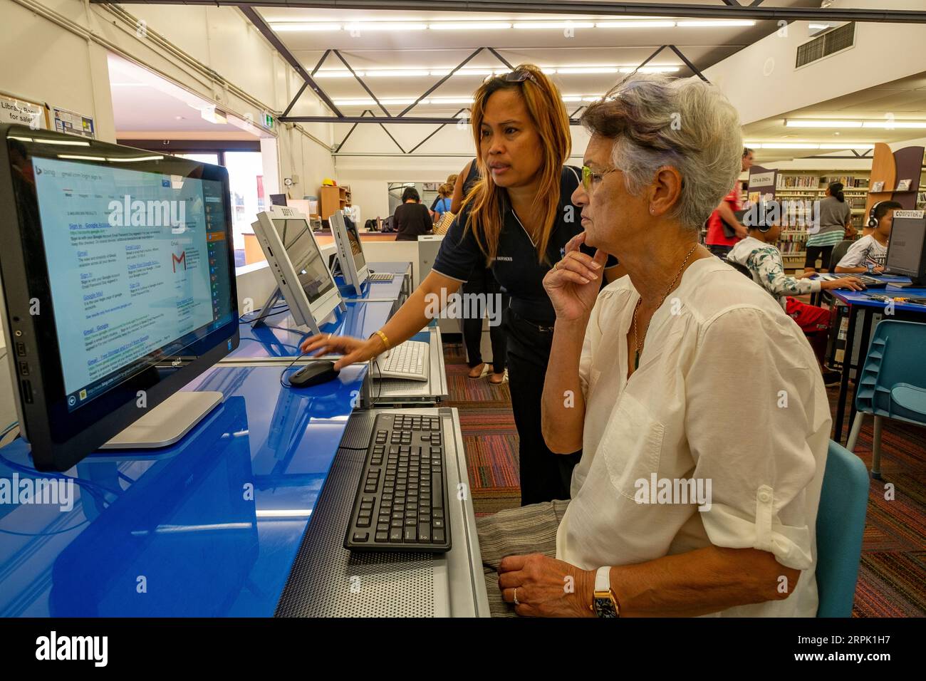 Eine ältere Frau, die einen kostenlosen Computer in einer Bibliothek in Mt Isa in Queensland, Australien, benutzt, um E-Mails auf Reisen zu sammeln Stockfoto