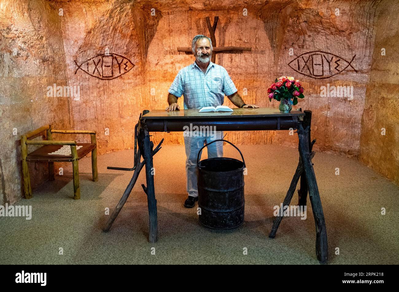 Ein anglikanischer Priester am Altar, der aus einer Bergbauwinde in einer unterirdischen Kirche in der Opalbergbaustadt Coober, Pady, South Australia, gebaut wurde Stockfoto