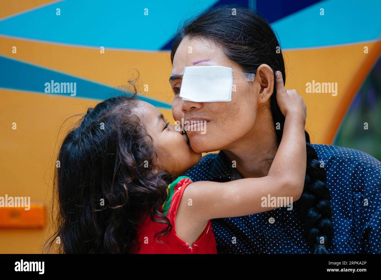 200105 -- PEKING, 5. Januar 2020 -- Summe Meyle erhält einen Kuss von ihrer Tochter vor einer Kataraktoperation im Kampong Cham Provinzkrankenhaus in Kampong Cham, Kambodscha, 15. März 2019. Sum Meyle, 36, ist eine alleinerziehende Mutter mit fünf Kindern. Sie hatte an Katarakt gelitten, nachdem ihr linkes Auge verletzt worden war, und verlor fast ihren Job als Schutzpatronin in Phnom Penh wegen des schlechten Sehvermögens. Am 15. März 2019 kam Meyle nach Kampong Cham, als ihr ein Freund erzählte, dass ein Team chinesischer Ärzte kostenlose Augenbehandlungen in einem örtlichen Krankenhaus durchgeführt habe. Doktor Liang Hao des ersten angeschlossenen Krankenhauses von G Stockfoto