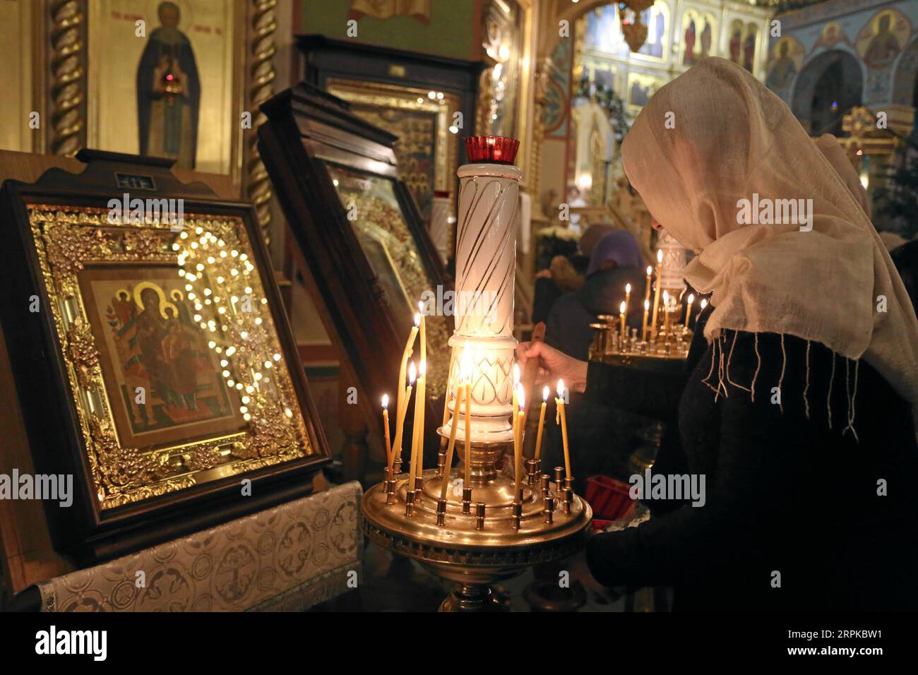 200106 -- RIGA, 6. Januar 2020 -- Eine Frau zündet eine Kerze während eines Weihnachtsgottesdienstes in Riga an, der orthodoxen Kathedrale zur Geburt Christi in Riga, Lettland, am 6. Januar 2020. Orthodoxe Christen feiern Weihnachten am 7. Januar nach dem Julianischen Kalender. Foto von /Xinhua LETTLAND-RIGA-ORTHODOX CHRISTMAS EdijsxPalens PUBLICATIONxNOTxINxCHN Stockfoto