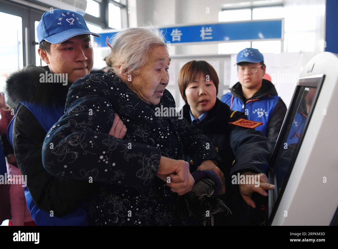 200113 -- LANZHOU, 13. Januar 2020 -- Freiwillige helfen einer älteren Frau, ihren vorläufigen Ausweis am Lanzhou Bahnhof in Lanzhou, der Hauptstadt der nordwestchinesischen Provinz Gansu, zu drucken, 13. Januar 2020. Während des Reisereims des Frühlingsfestes führen der Bahnhof Lanzhou und der Westbahnhof Lanzhou einen besonderen Freiwilligendienst namens Steward of the Journey ein. Für Passagiere, die einen Termin vereinbart haben, in Eile in die Züge steigen oder nicht mit dem mobilen Fahrkartensystem vertraut sind, stehen Freiwillige zur Verfügung, die ihnen helfen, die Zeit des Einfahrens in die Züge zu verkürzen und Passe zu bringen Stockfoto