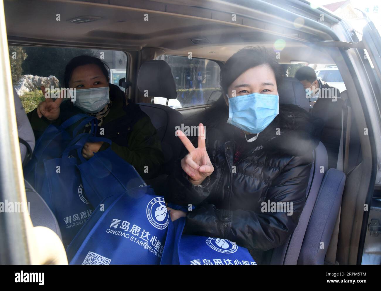 200130 -- QINGDAO, 30. Januar 2020 -- Zhang Guimin R und Wu Wei, Mitglieder des medizinischen Teams, Gesten, bevor sie nach Wuhan der Provinz Hubei in Qingdao, ostchinesische Provinz Shandong, gehen, 30. Januar 2020. Sieben medizinische Mitarbeiter aus zwei privaten Krankenhäusern in Qingdao bildeten ein medizinisches Team und reisten am Donnerstag nach Wuhan, um dort die Coronavirus-Bekämpfung zu unterstützen. CHINA-SHANDONG-PRIVATE KRANKENHÄUSER-MEDIZINISCHE TEAM-HILFE CN WANGXKAI PUBLICATIONXNOTXINXCHN Stockfoto