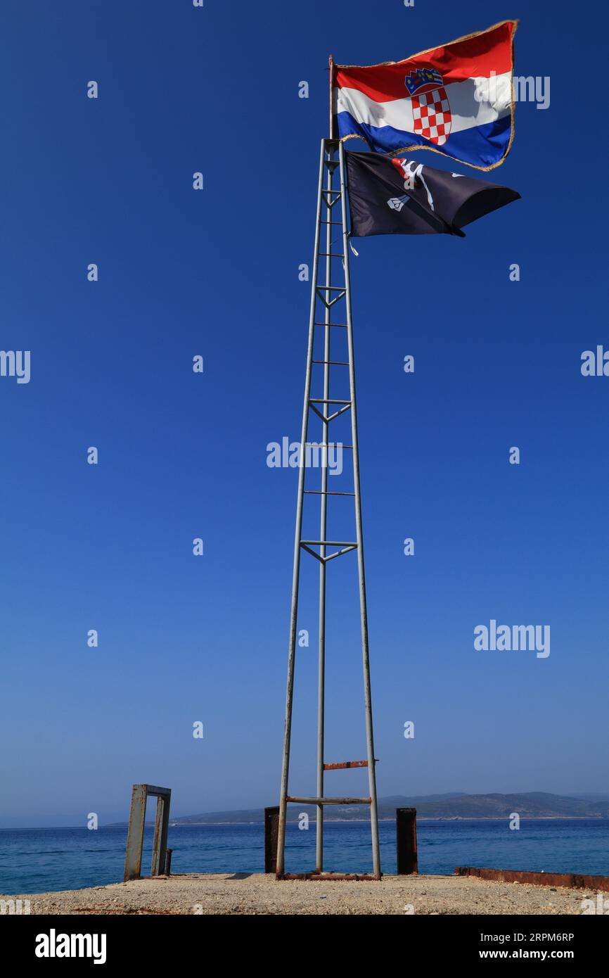 Kroatische Flagge und Piratenflagge auf einem hohen Mast Stockfoto