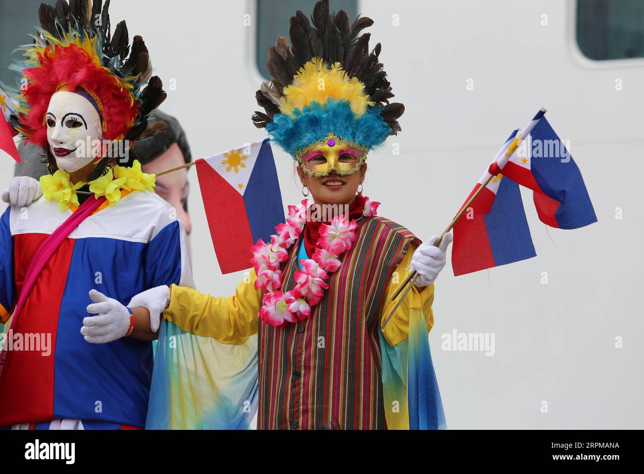 Philippinische fiesta-Motto Willkommensfeier für Kreuzfahrtschiff am Manila Pier : Musiker mit Bambusinstrumenten, philippinische Tänzer, Higantes, Flaggen Stockfoto