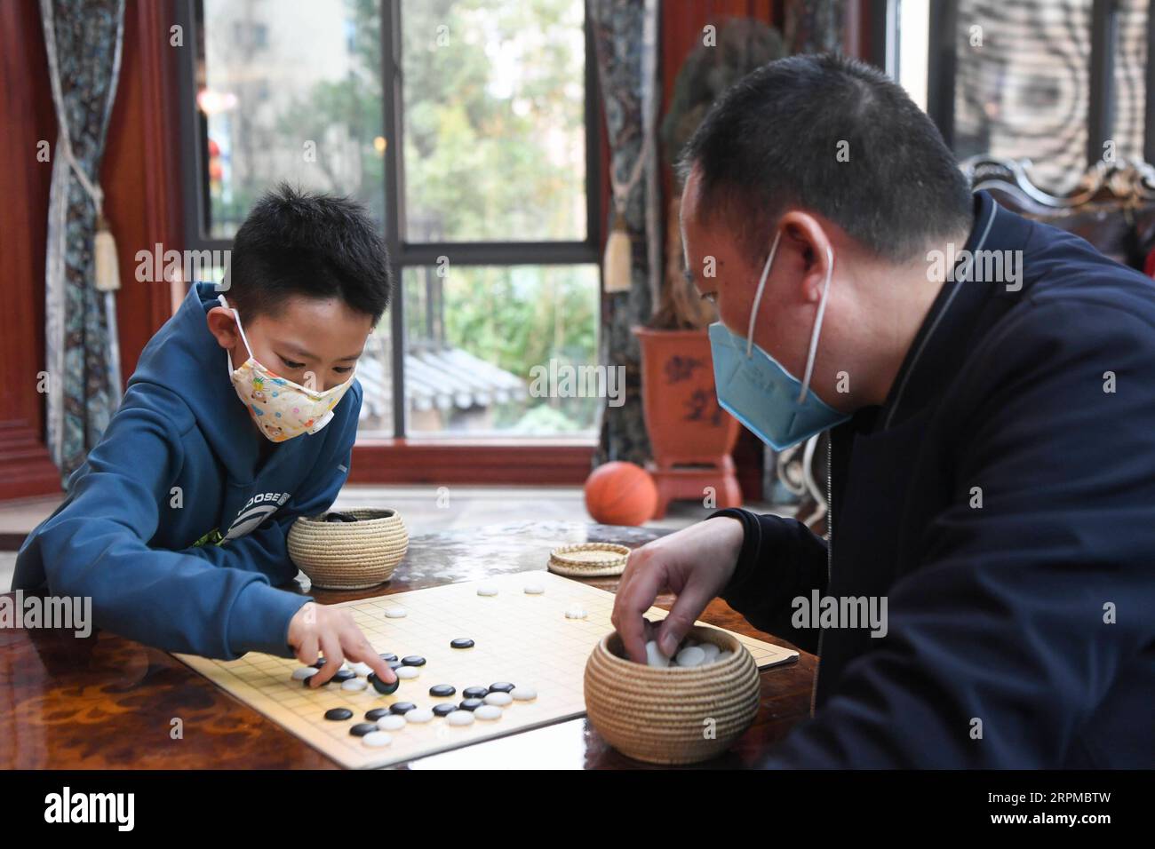 200207 -- PEKING, 7. Februar 2020 -- Wang Congyang L spielt Schach mit seinem Vater zu Hause im Yunyang County, südwestchinesisches Chongqing, 6. Februar 2020. Die lokale Bildungsverwaltung rät den Schülern, weniger Ausflüge nach draußen zu Unternehmen und Menschenmassen zu vermeiden, die durch den neuartigen Coronavirus-Ausbruch verursacht werden. Die Schüler werden ermutigt, während der Winterferien zu lesen und zu lernen, Indoor-Übungen zu machen und bei der Arbeit zu Hause zu helfen. XINHUA FOTOS DES TAGES WangxQuanchao PUBLICATIONxNOTxINxCHN Stockfoto