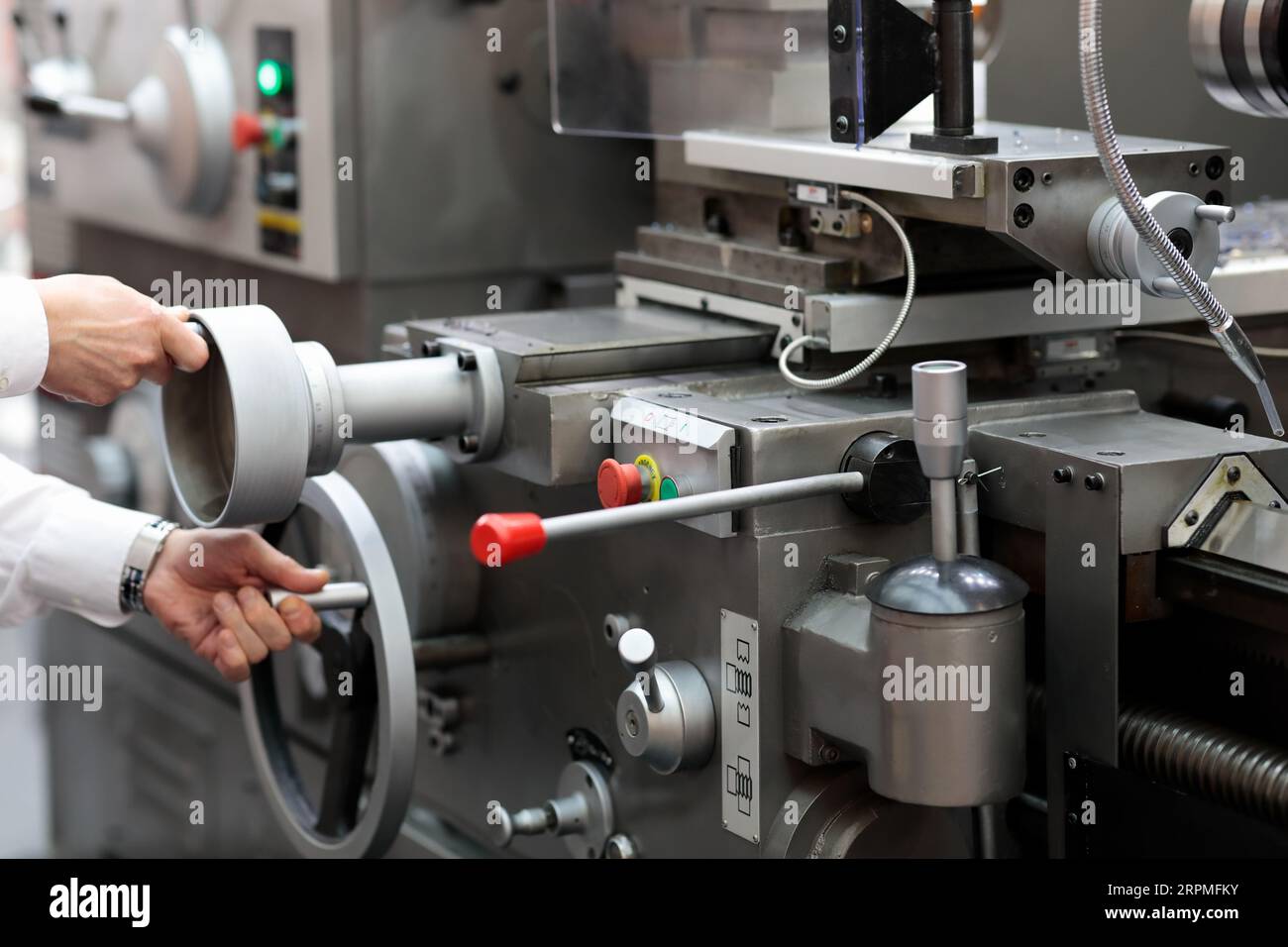 Ingenieur, der eine konventionelle Metalldrehmaschine in einer Fabrik aufbaut. Selektiver Fokus. Stockfoto