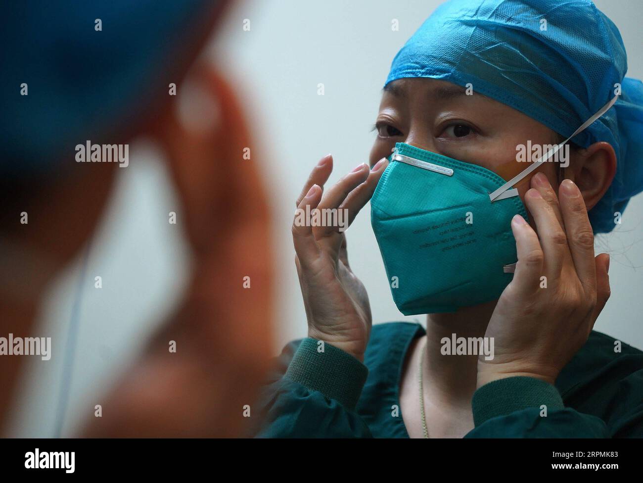 200213 -- NANCHANG, 13. Februar 2020 -- Krankenschwester Zhang Xiao zieht eine Maske im Xianghu Krankenhaus des ersten angeschlossenen Krankenhauses der Nanchang Universität in Nanchang, ostchinesische Provinz Jiangxi, 5. Februar 2020 an. Im Zuge des neuartigen Coronavirus-Ausbruchs engagieren sich zahlreiche medizinische Fachkräfte im Kampf gegen das Virus. Am 5. Februar um etwa 20:00 Uhr raste ein Krankenwagen im Xianghu Krankenhaus, zusammen mit schwer erkrankten Patienten, die mit einer neuartigen Coronavirus-Pneumonie aus Fuzhou der Provinz Jiangxi infiziert waren. Ärzte und Krankenschwestern legen sofort Schutzausrüstung an, um die Behandlung durchzuführen. Drei Stunden später noch ein paar Meter Stockfoto