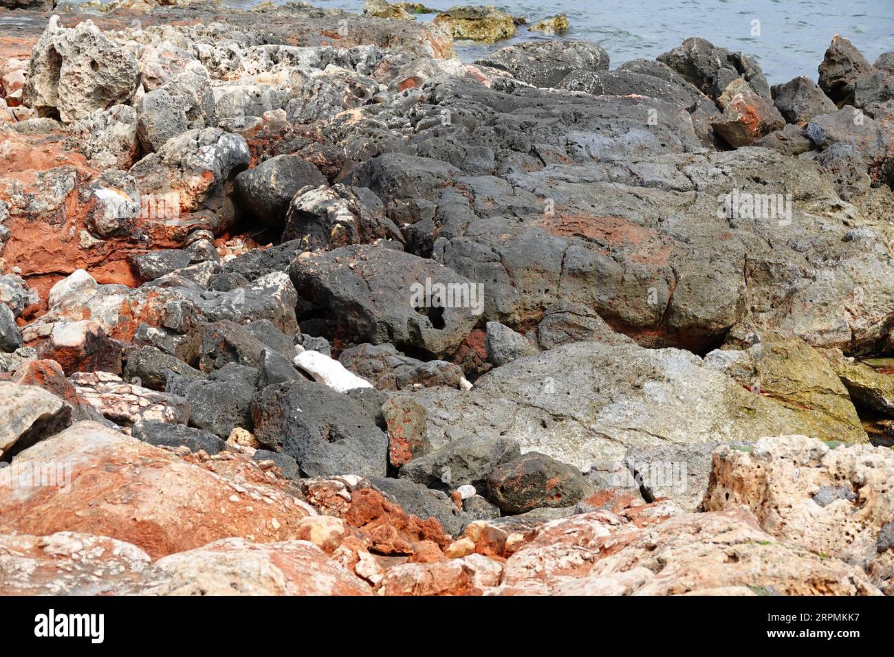 Ein Blick auf die Küste Mallorcas mit einem Vorder aus abgekühlten Lavafelsen Stockfoto