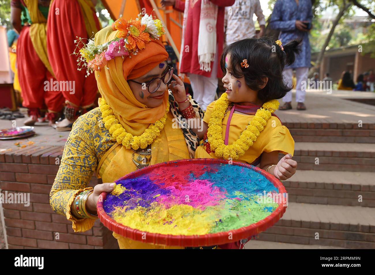 200214 -- , 14. Februar 2020 -- Eine Frau lächelt, während ihr Kind während des Pahela Falgun Festivals in Bangladesch am 14. Februar 2019 farbiges Puder auf ihr Gesicht aufträgt. Die Menschen in Bangladesch feierten am Freitag Pahela Falgun und läuteten die Ankunft des Frühlings ein. STR/Xinhua BANGLADESCH--SPRING-FESTIVAL dhaka PUBLICATIONxNOTxINxCHN Stockfoto