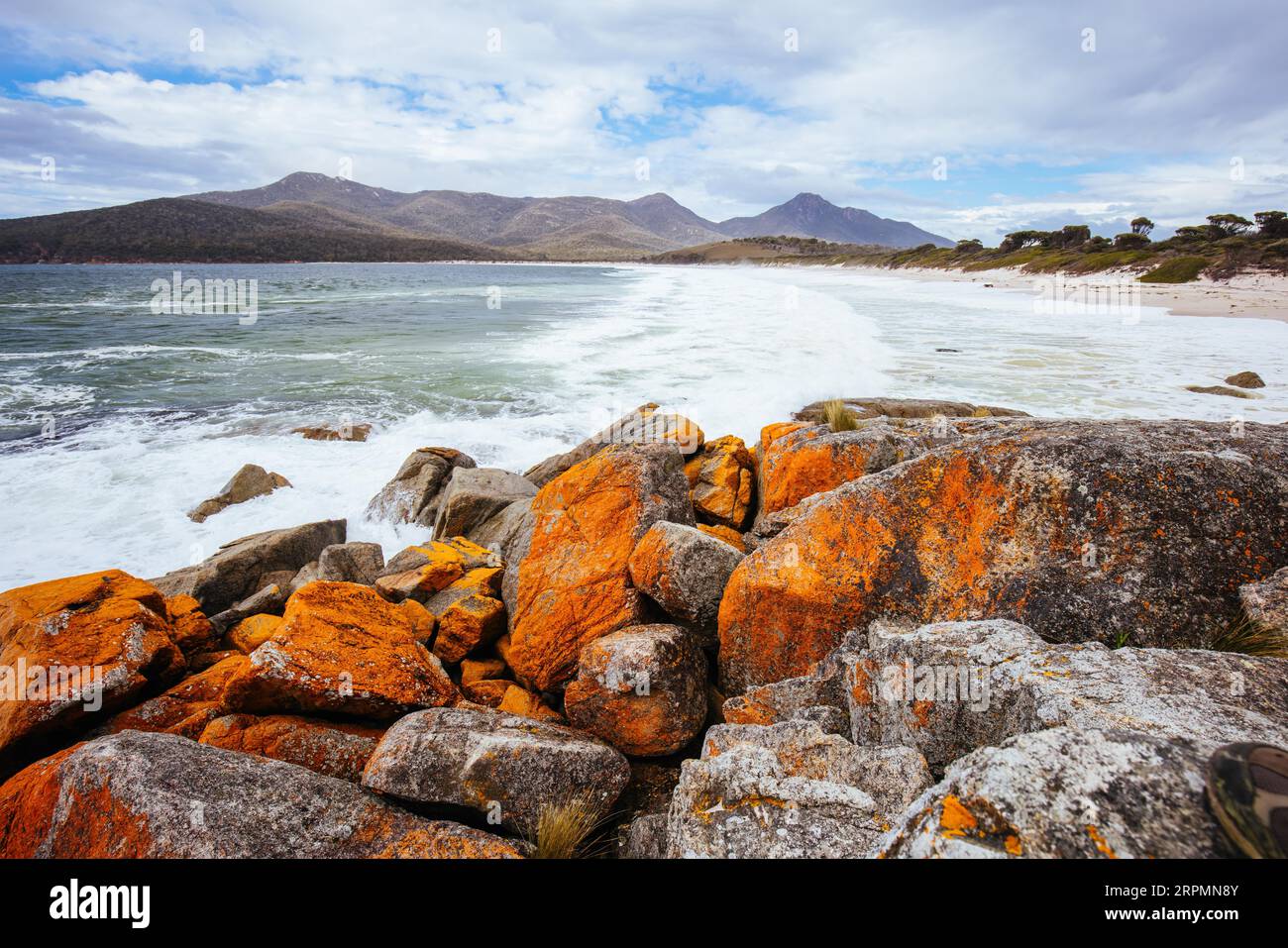Wineglass Bay Beach und seine orangen Flechtensteine an einem rauen Tag auf der Freycinet Peninsula in Tasmanien, Australien Stockfoto