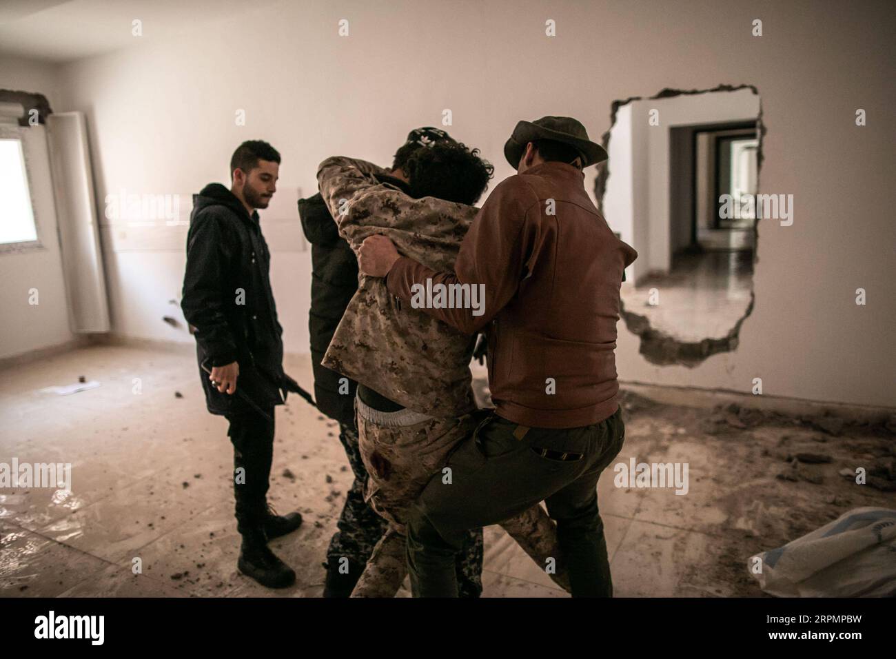200215 -- TRIPOLI, 15. Februar 2020 Xinhua -- Kämpfer der von den Vereinten Nationen unterstützten libyschen Regierungstruppen tragen einen verwundeten Soldaten bei den Zusammenstößen mit LNA-Truppen der libyschen Nationalarmee an der Salah Al-DIN-Frontlinie in Tripoli, Libyen, am 15. Februar 2020. Foto von Amru Salahuddien/Xinhua LIBYA-TRIPOLI-CONFLICT-FRONTLINE PUBLICATIONxNOTxINxCHN Stockfoto